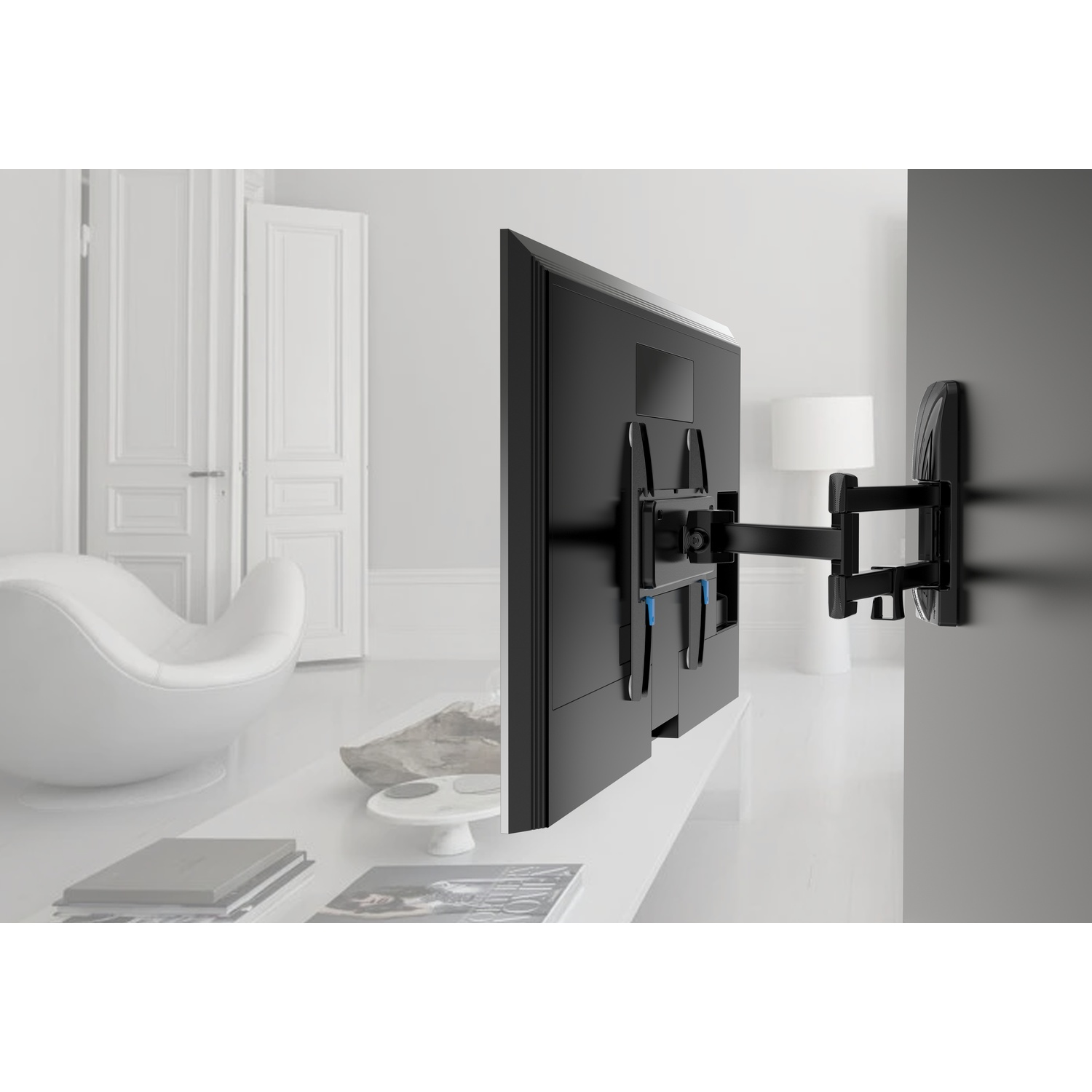 Un TV nero è montato su una staffa a muro in un soggiorno moderno con mobili bianchi.