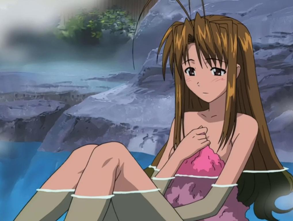 Anime-Mädchen mit langen braunen Haaren sitzt in blauem Wasser vor Felsen.