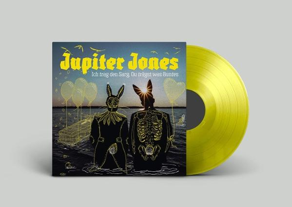Jupiter Jones Albumcover mit gelber Vinylscheibe. Zwei Figuren in Hasenmützen, einer mit Skelett-Design.