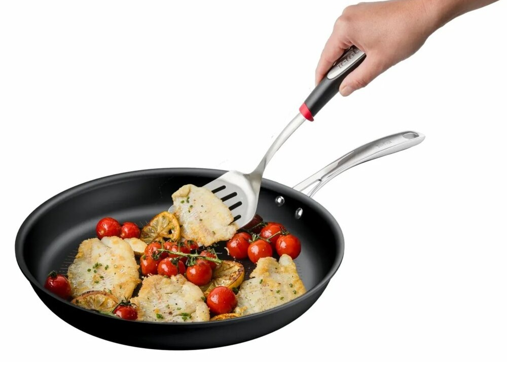 Filety rybne z pomidorkami i plasterkami cytryny na patelni.