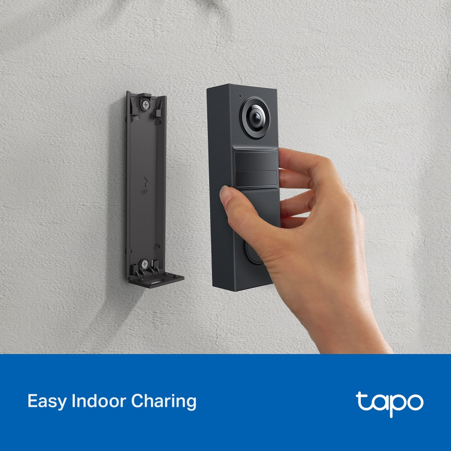 Hand attaching a gray doorbell to a wall mount.