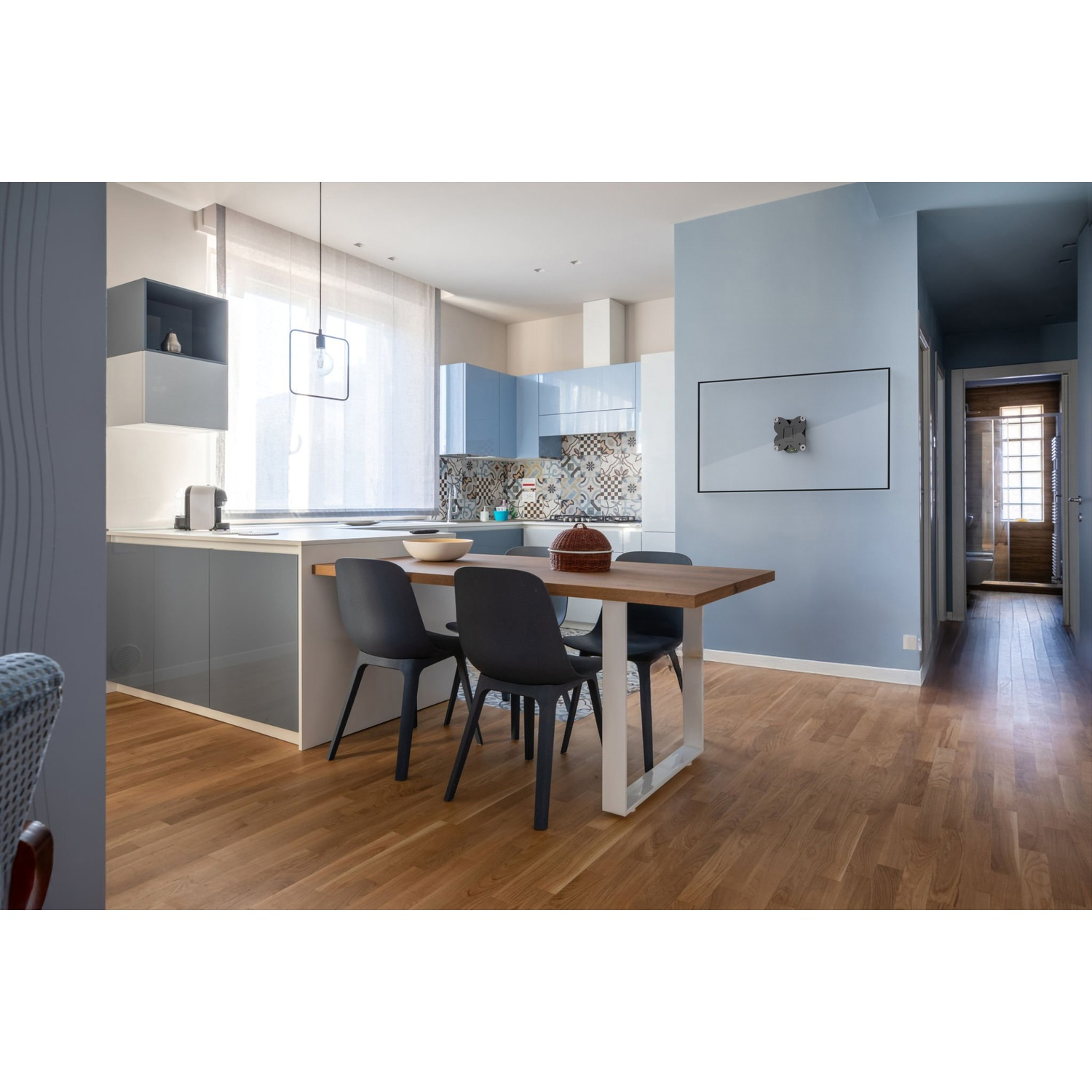 Tavolo da pranzo in legno con quattro sedie in una stanza moderna blu.