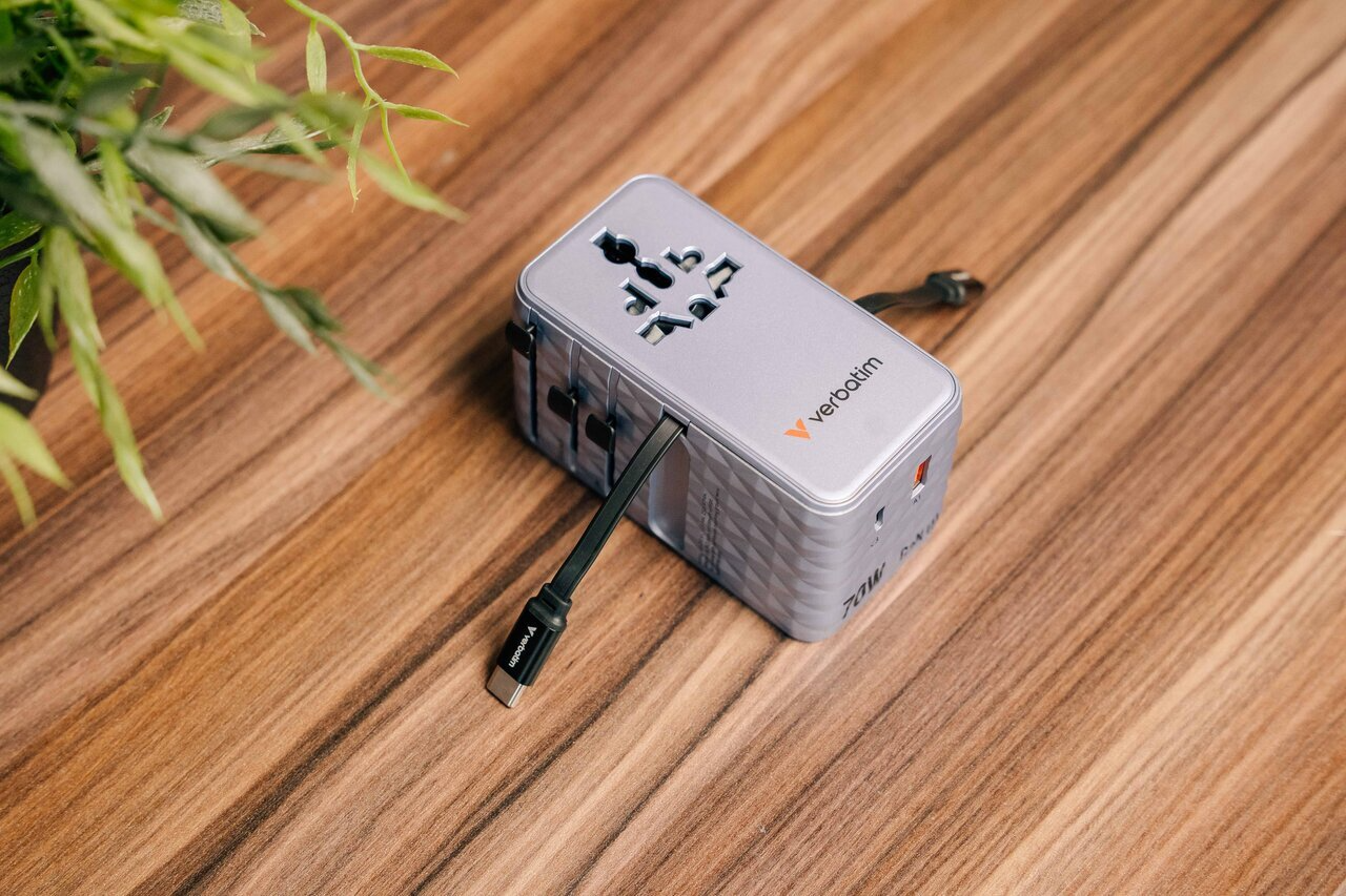 Ezüst univerzális adapter USB-C kábellel fa háttéren.