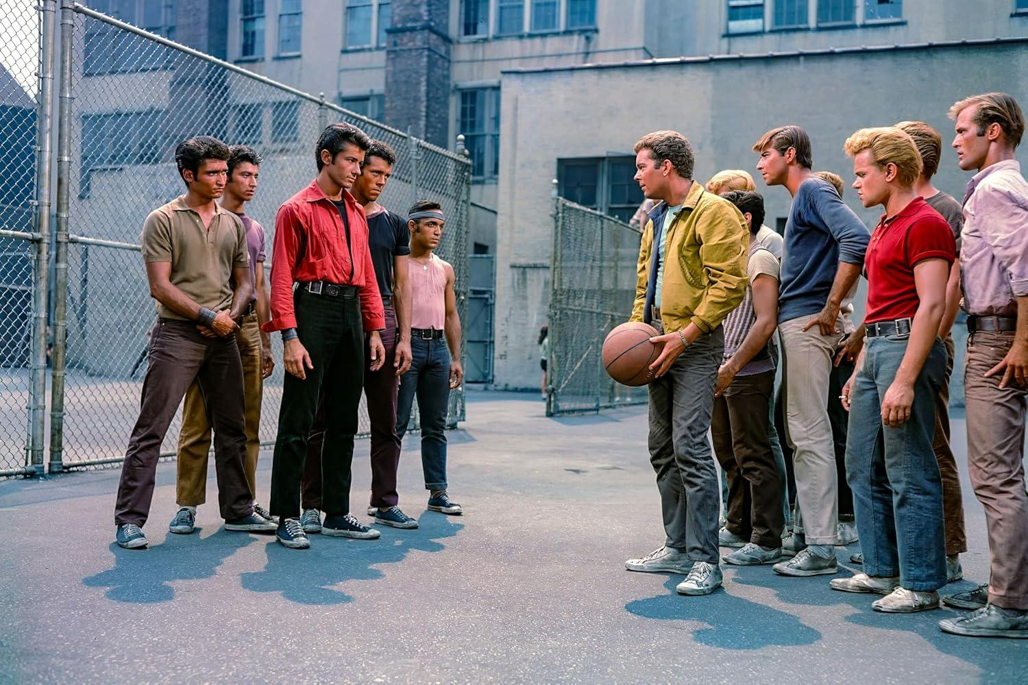 Junge Männer in 1950er Kleidung stehen auf einem Freiplatz, einer hält einen Basketball.