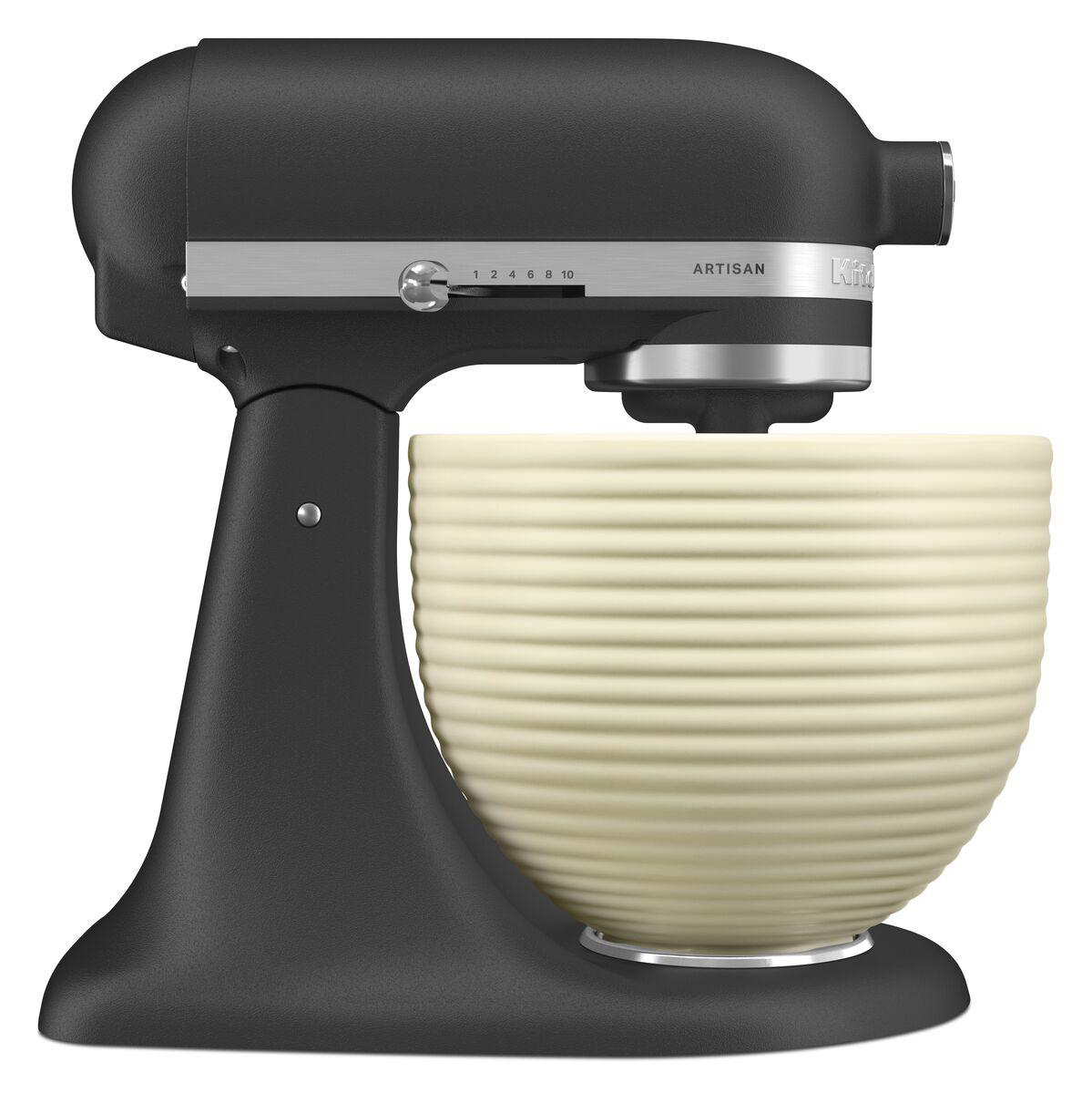 Ein schwarzer Küchenmaschinen-Standmixer mit cremefarbenem Rillenschüsselaufsatz.
