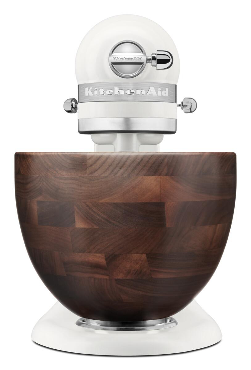 Ein weißer KitchenAid Standmixer mit einem Holzschüsselaufsatz.