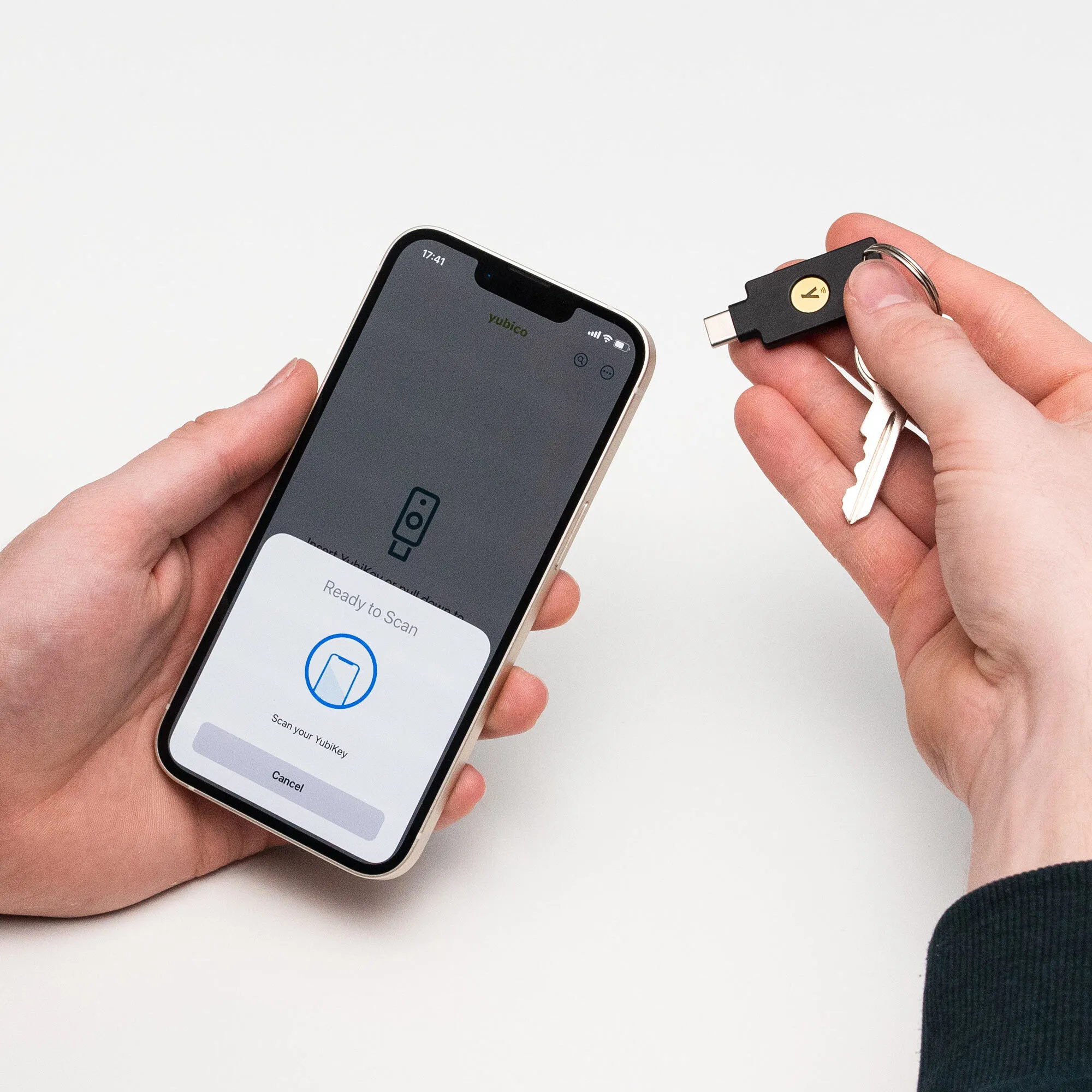 Ein Smartphone zeigt „Bereit zum Scannen“ an, während ein YubiKey mit Schlüsseln gehalten wird.