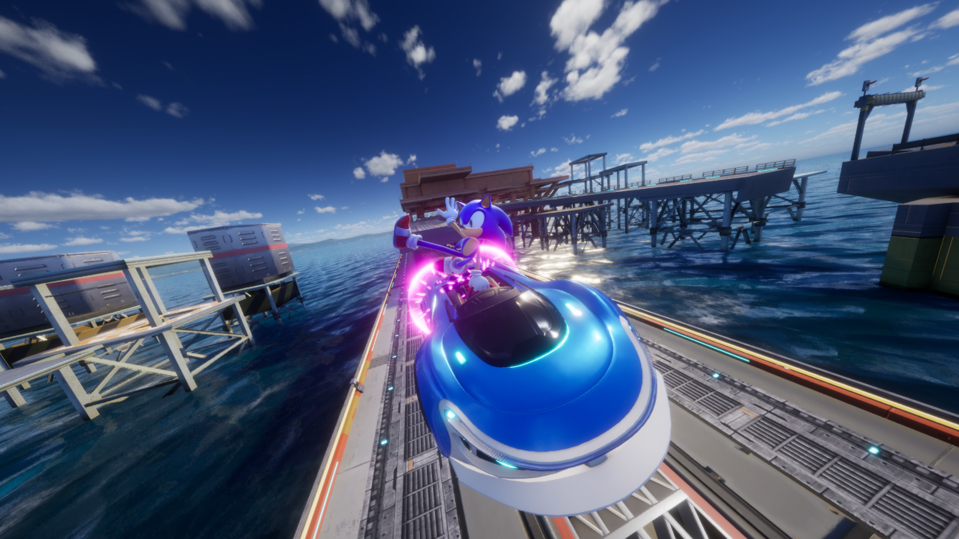 Sonic corre in un go-kart blu su un binario sull'acqua, con moli sullo sfondo.