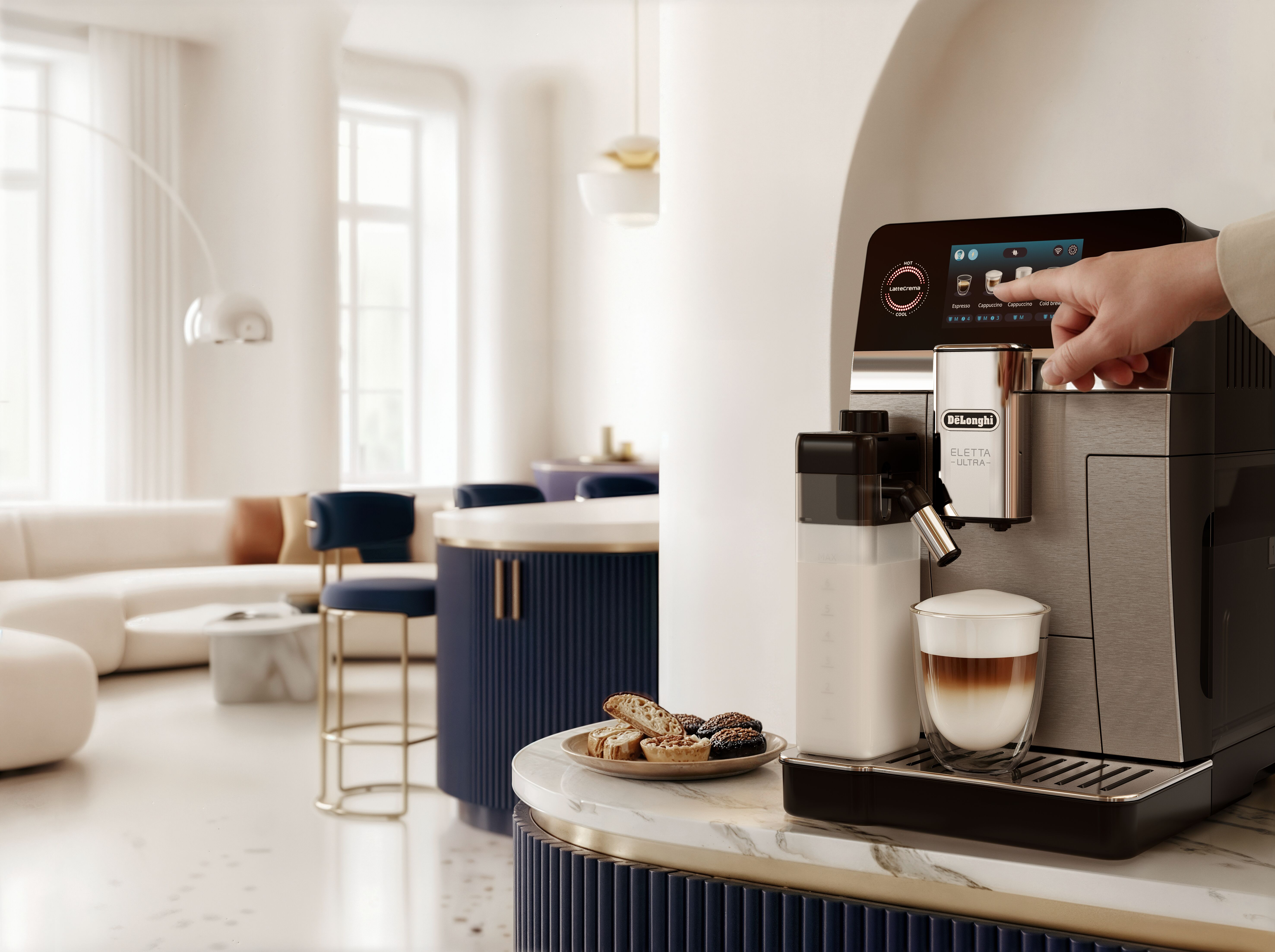 Eine Hand bedient eine Kaffeemaschine, ein Kaffee steht daneben.