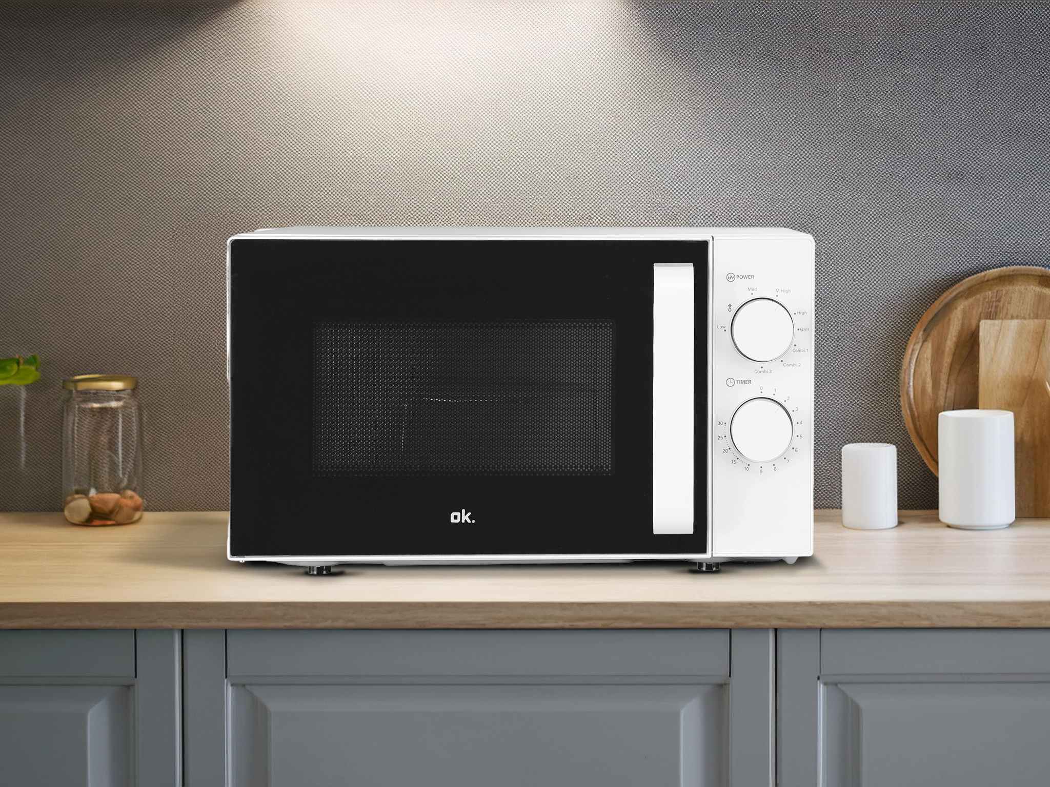 Biała kuchenka mikrofalowa ok. z czarnymi drzwiami stoi na blacie.