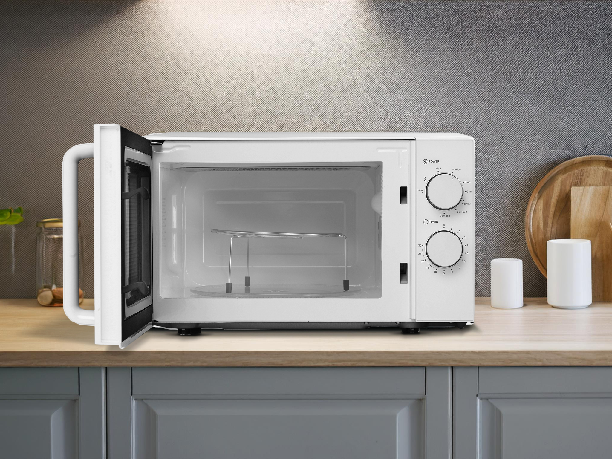 Biała otwarta kuchenka mikrofalowa z funkcją grilla i minutnikiem na blacie.