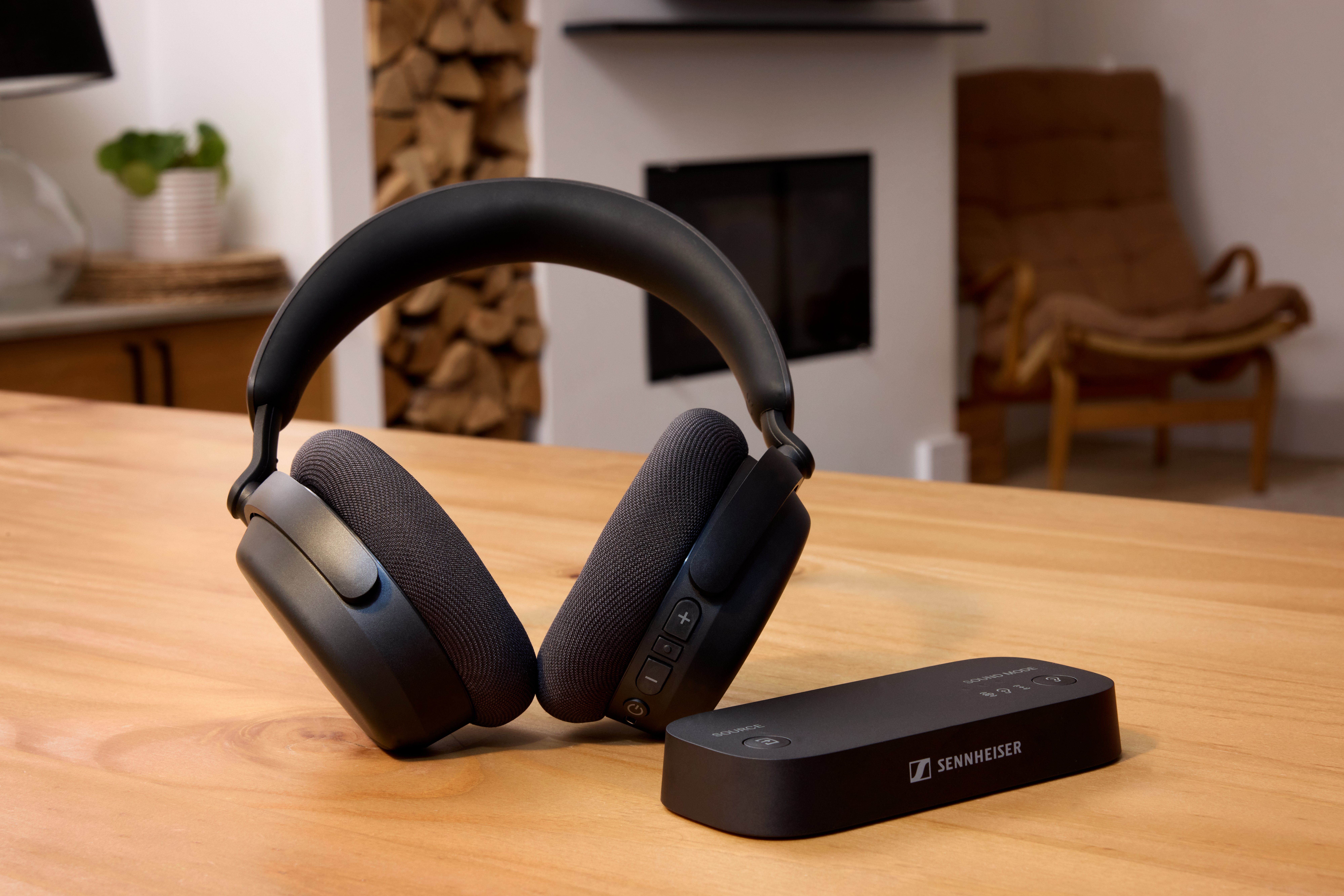Schwarze Kopfhörer und Sennheiser-Sender auf einem Holztisch.