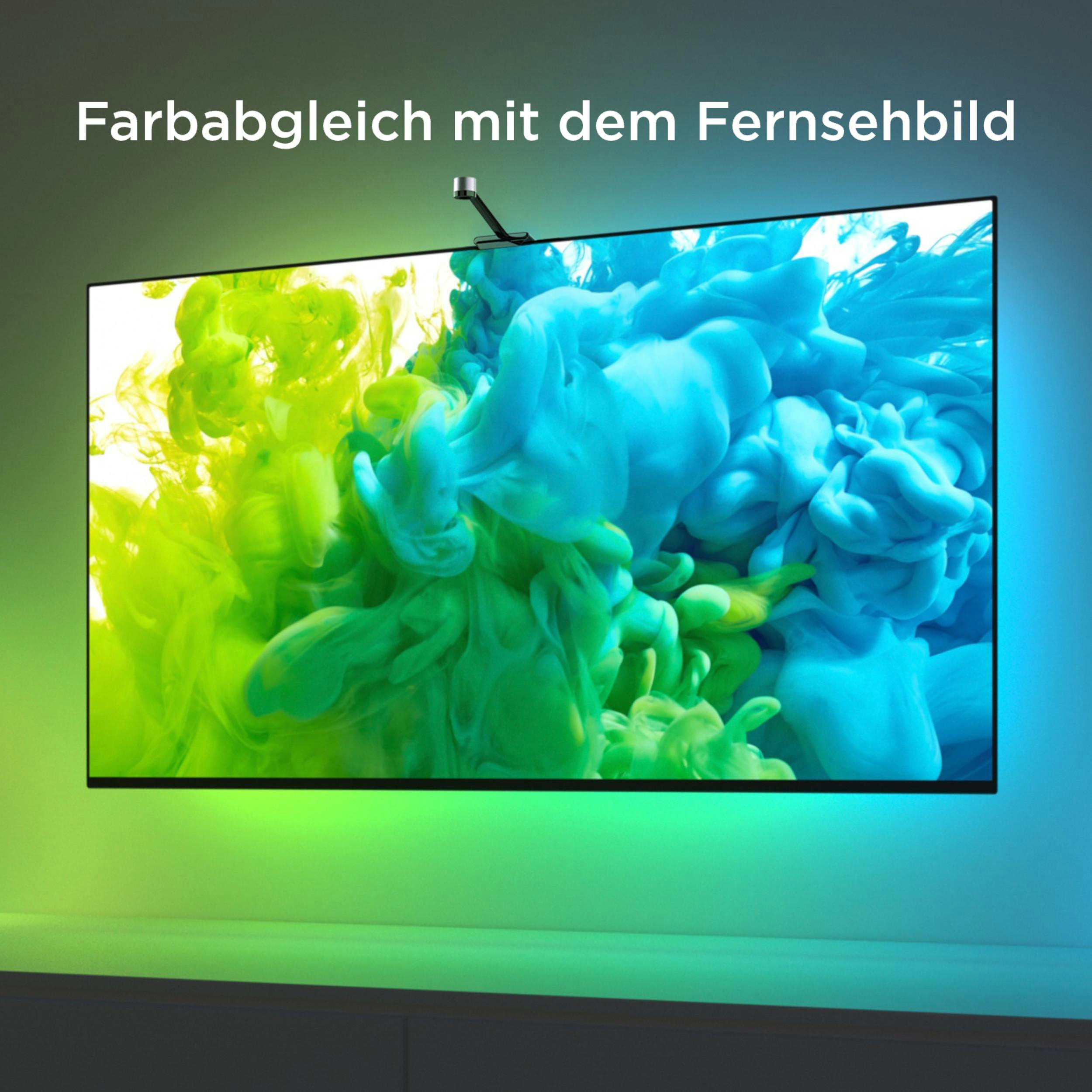 Ein Fernseher zeigt grüne und blaue Farbnebel. Eine Kamera ist oben angebracht.
