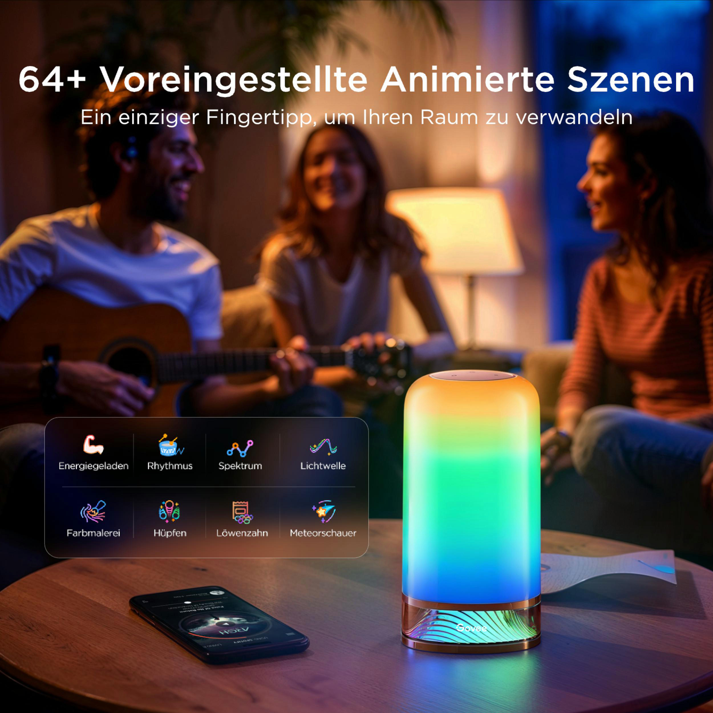 Personen spielen Gitarre, eine Lampe leuchtet bunt, Handy auf dem Tisch.