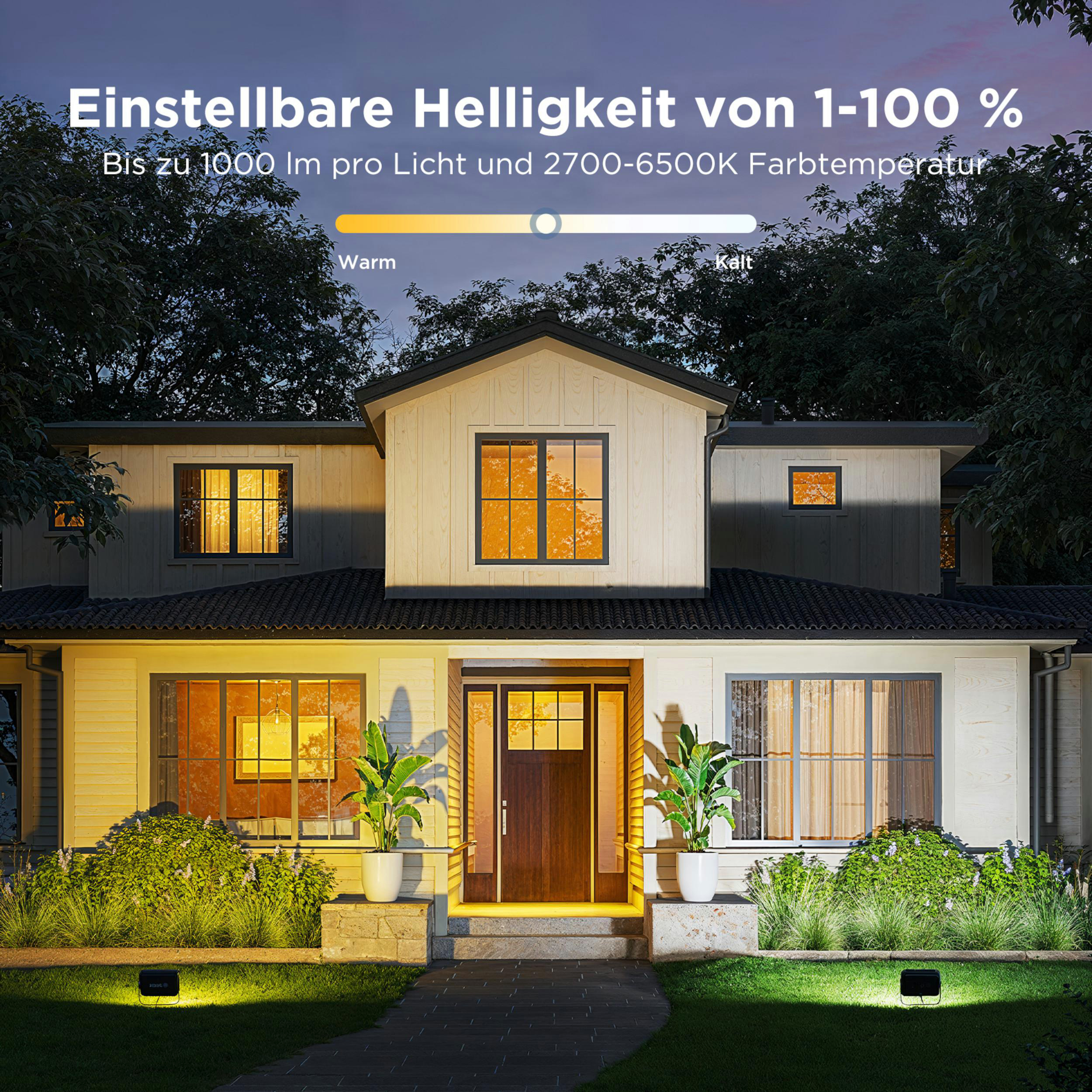 Hausfassade mit Fenstern und Eingang, beleuchtet durch warme Außenleuchten.