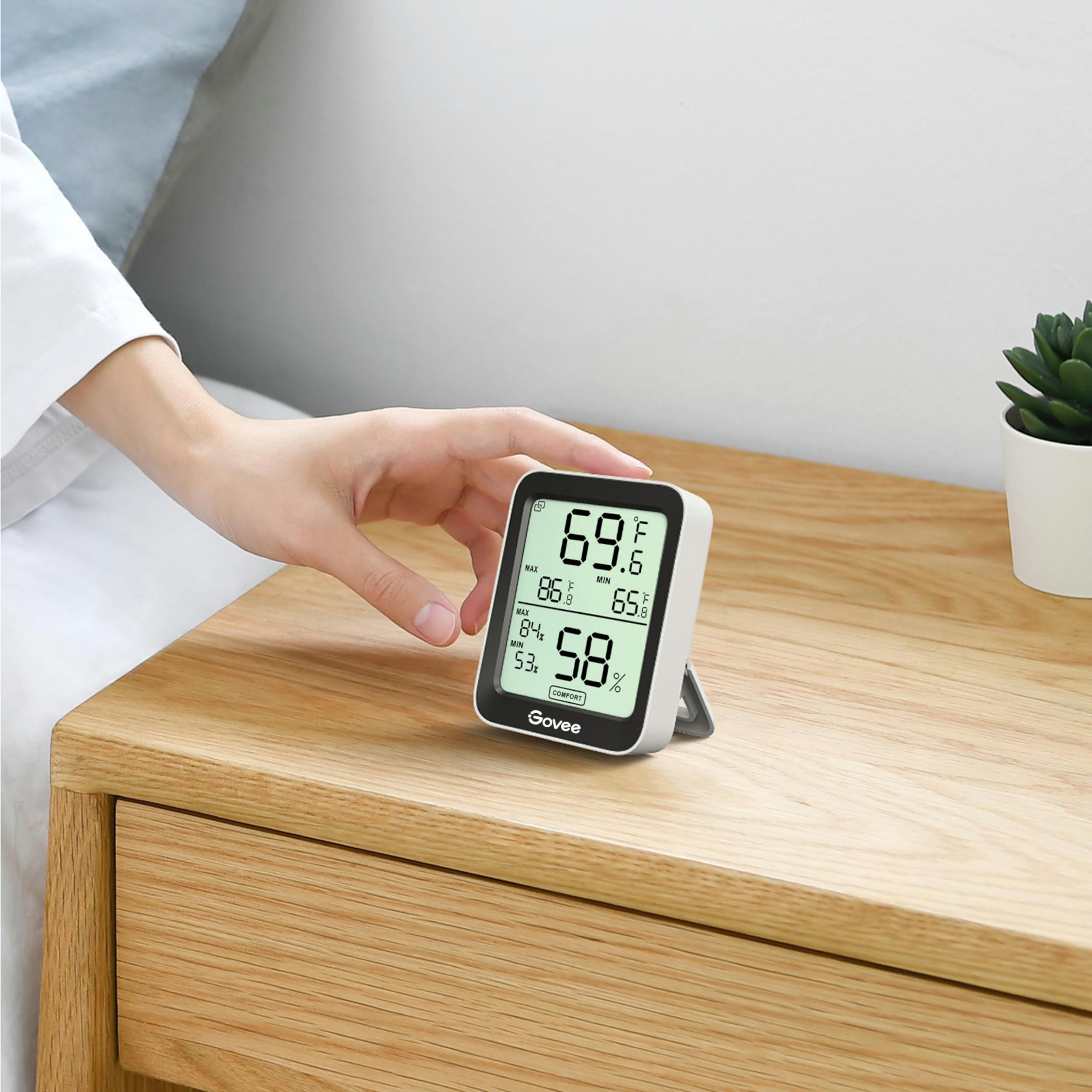 Ein Govee-Thermometer/Hygrometer auf Nachttisch aus Holz zeigt 69.8F und 58% Luftfeuchtigkeit.