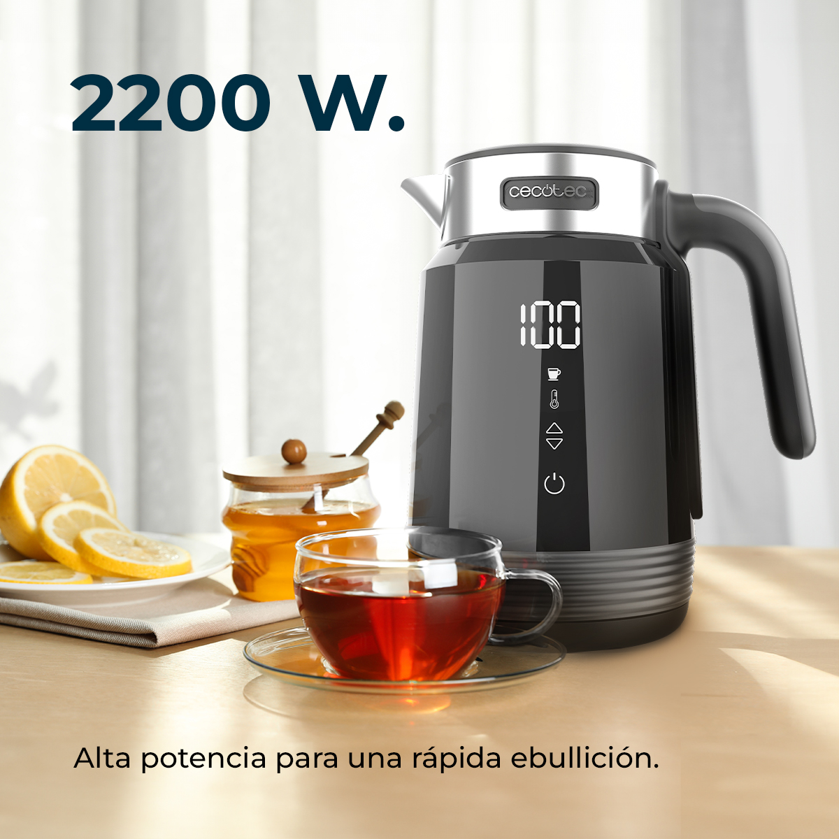Un hervidor eléctrico negro con pantalla digital junto a una taza de té, miel y rodajas de limón.