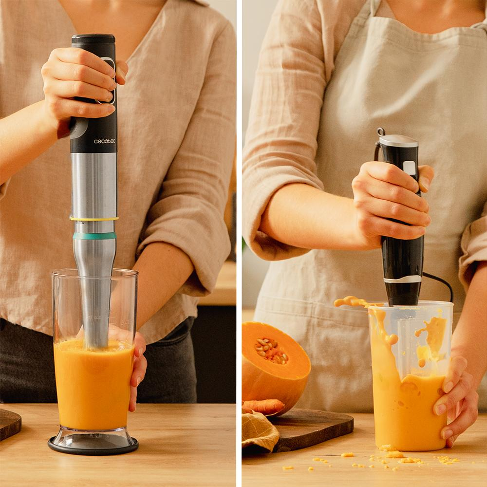 Una mano usa una batidora de inmersión en un vaso de zumo de naranja.