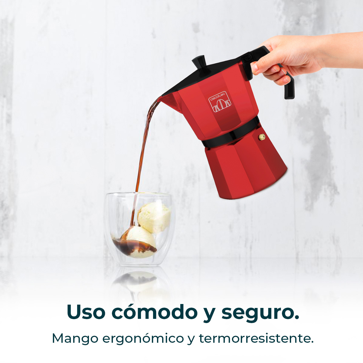 Una cafetera roja vierte café sobre helado en un vaso.