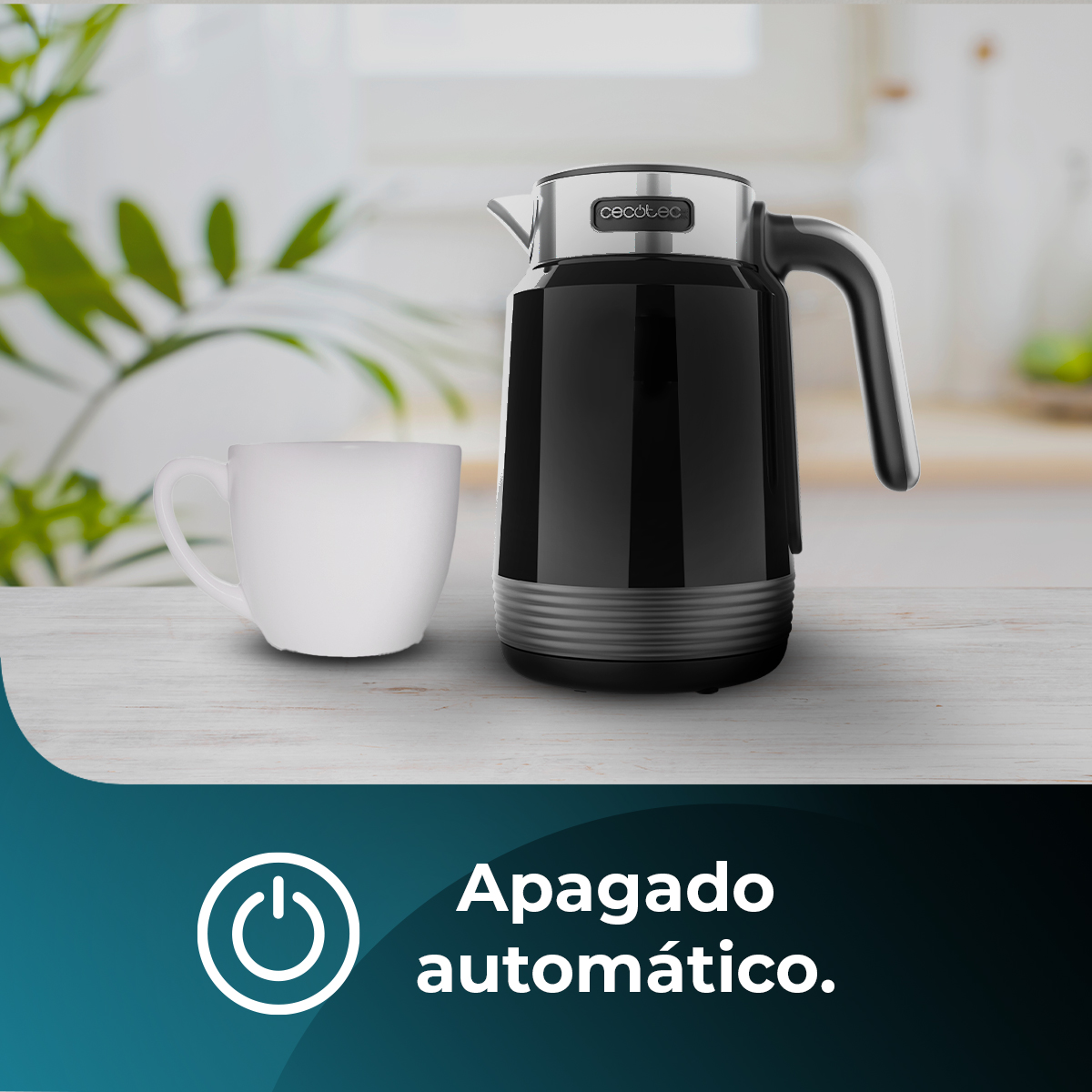 Jarra termo negra con taza blanca sobre mesa madera.