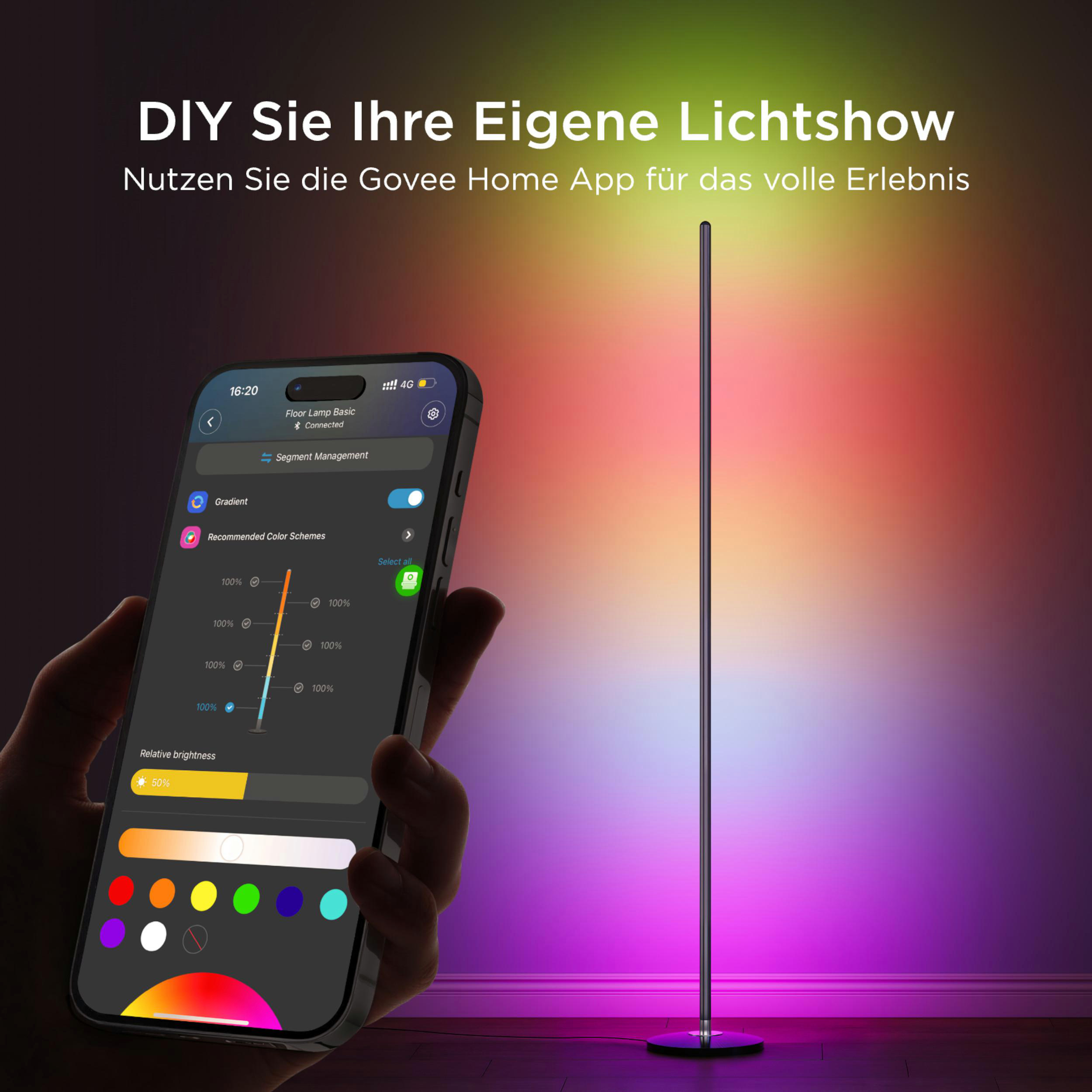 Eine Hand hält ein Smartphone, das eine App zur Steuerung einer Stehlampe zeigt. Die Lampe leuchtet in bunten Farben.