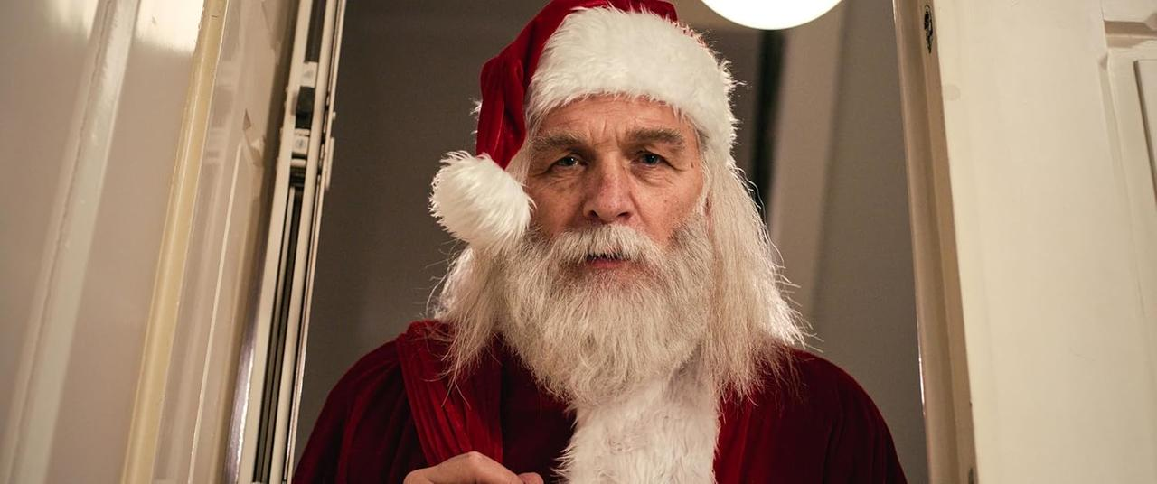 Ein Mann mit Bart und Weihnachtsmannmütze blickt in die Kamera.