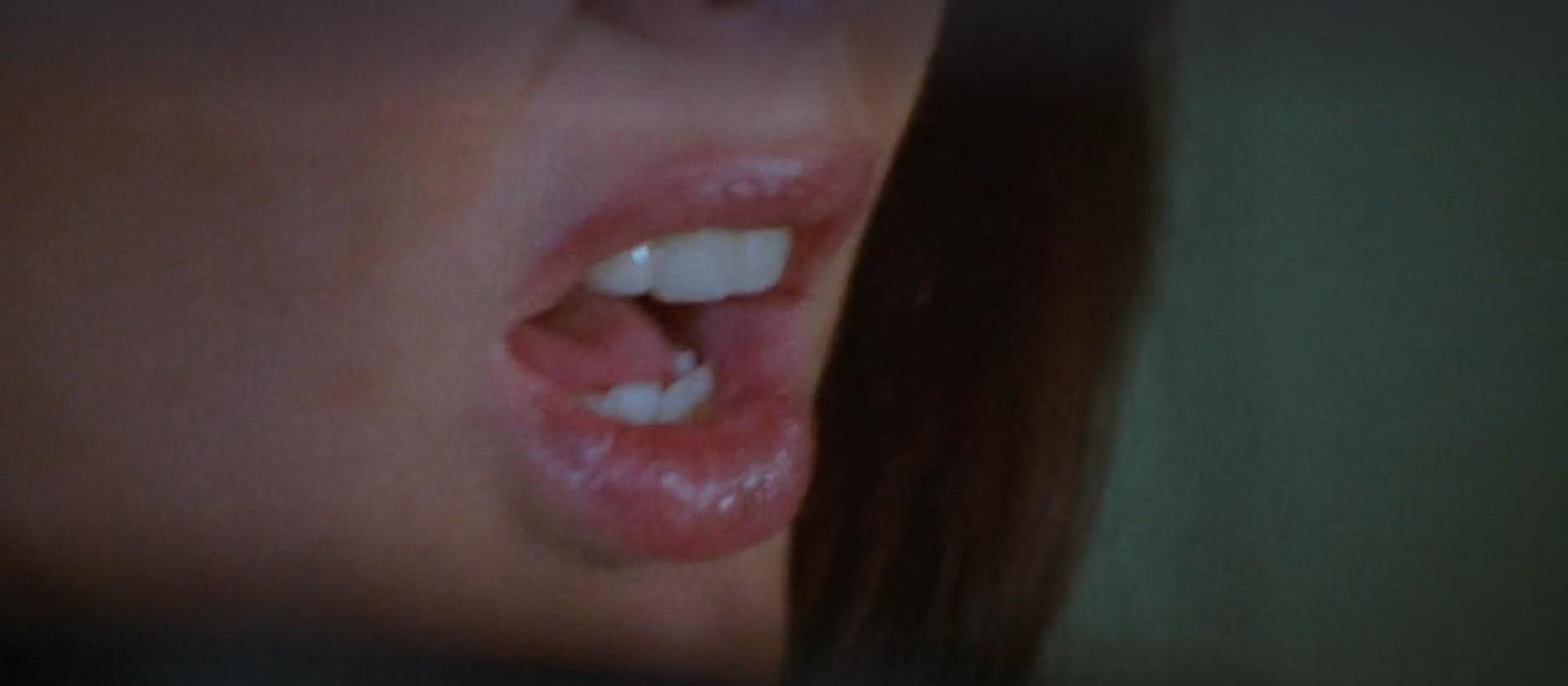Nahaufnahme von Lippen und Zähnen, mit glänzendem Lippenstift.