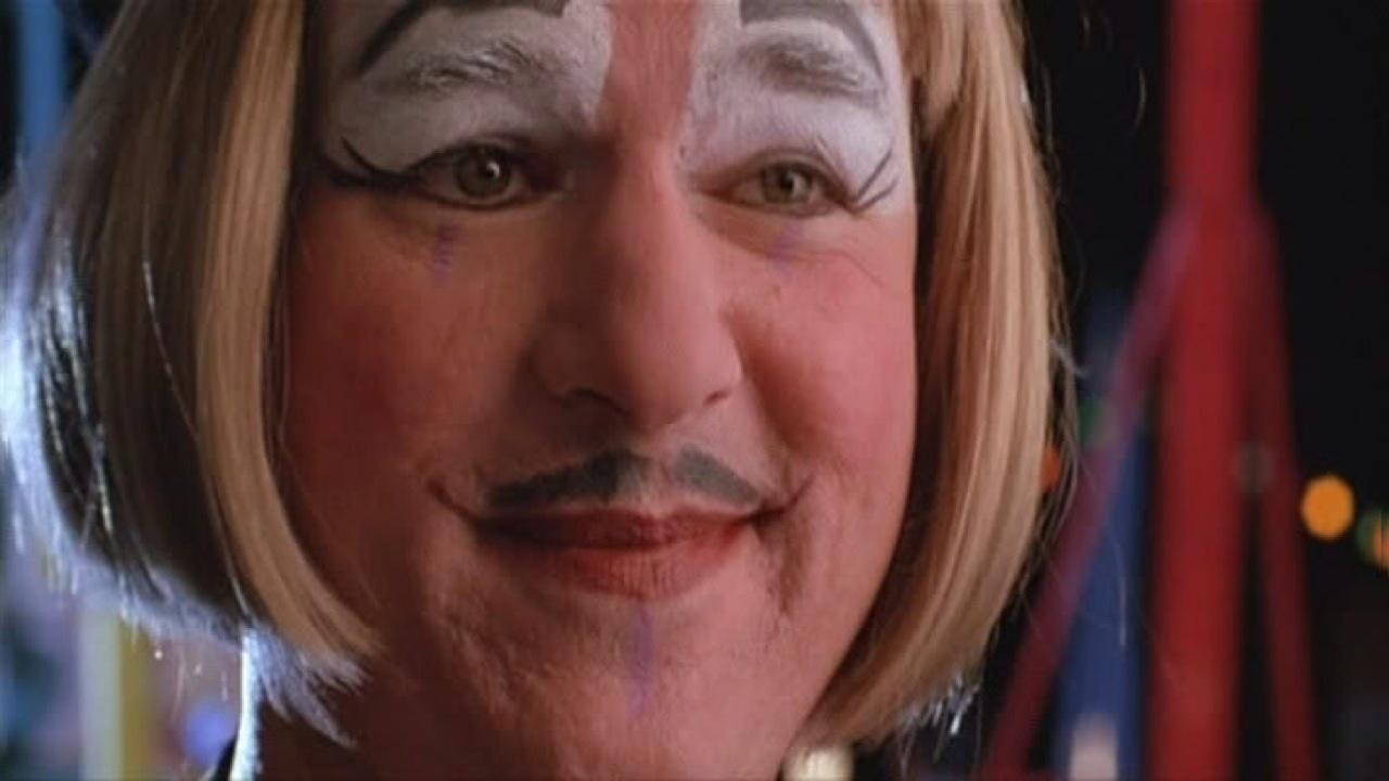 Nahaufnahme eines Mannes mit Clown-Make-up, Perücke und Schnurrbart.