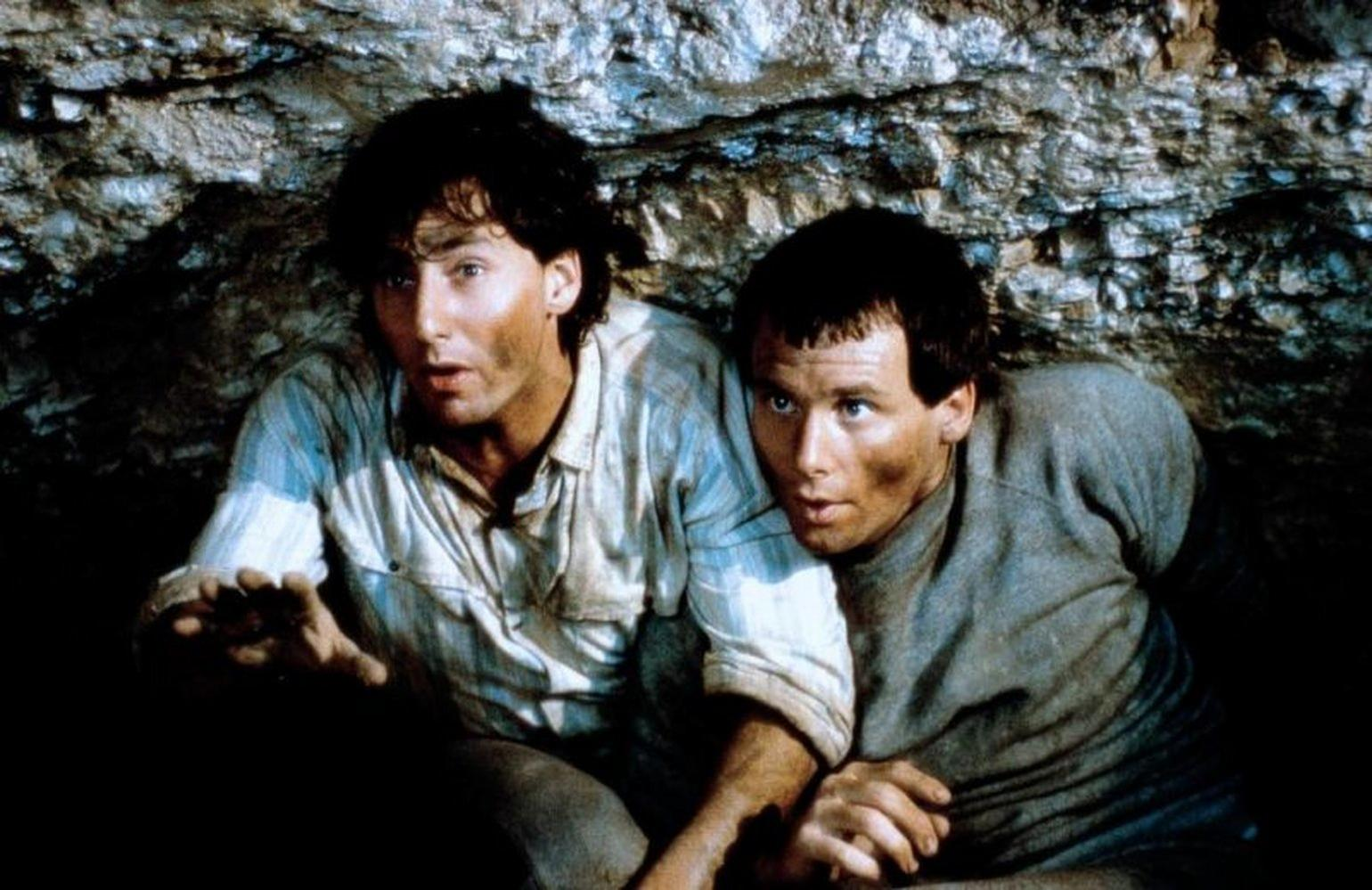 Zwei Männer kauern in einer Höhle. Beide haben Schmutz im Gesicht und an der Kleidung.