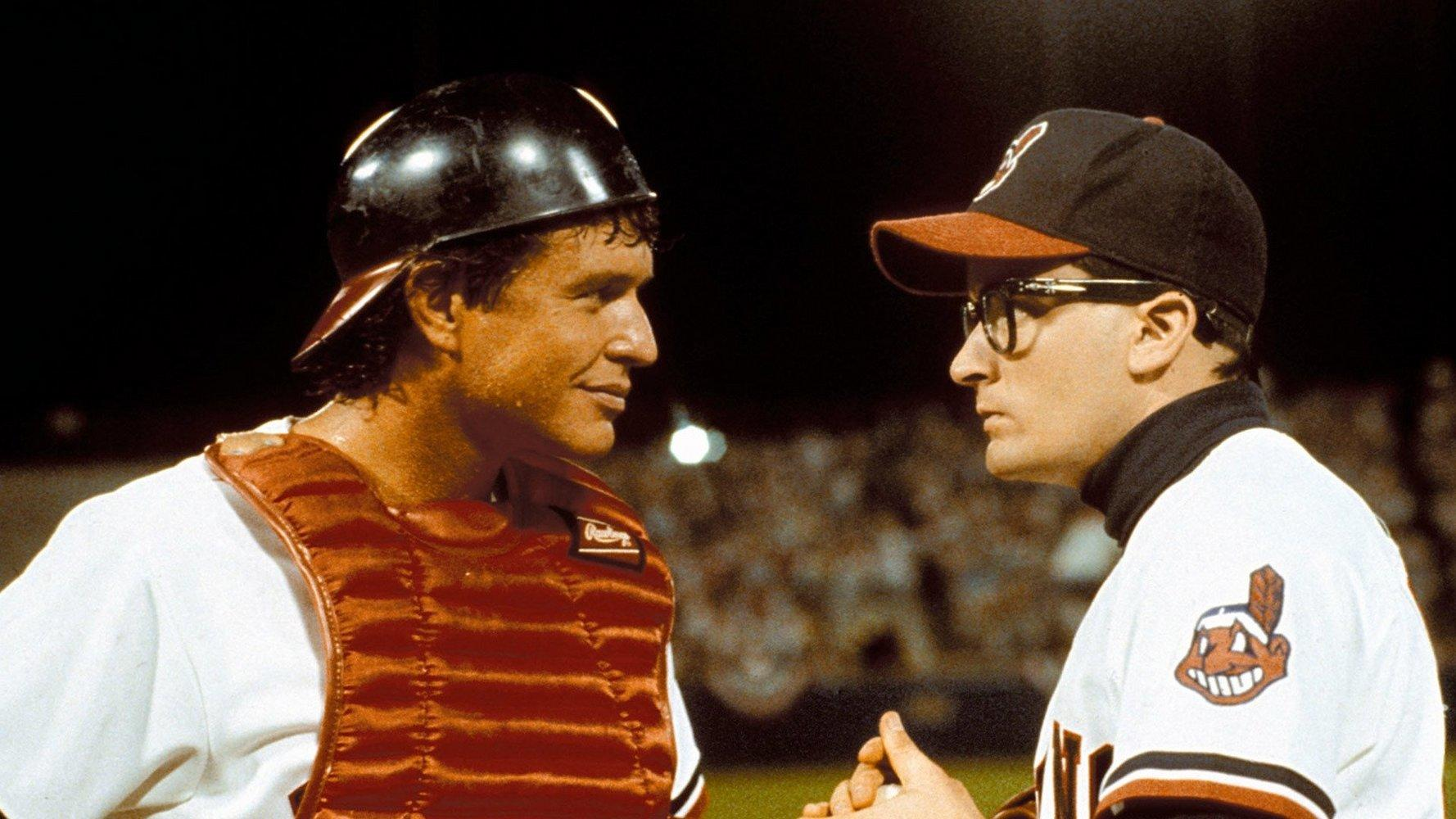 Ein Baseballspieler mit Helm und Schutzausrüstung spricht mit einem Trainer.