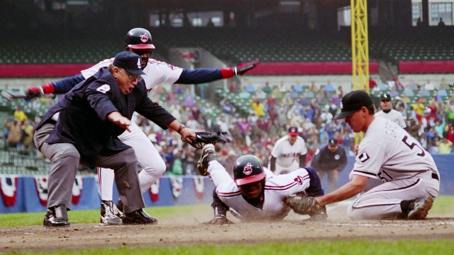 Baseballspieler rutscht zur Base, Umpire entscheidet.