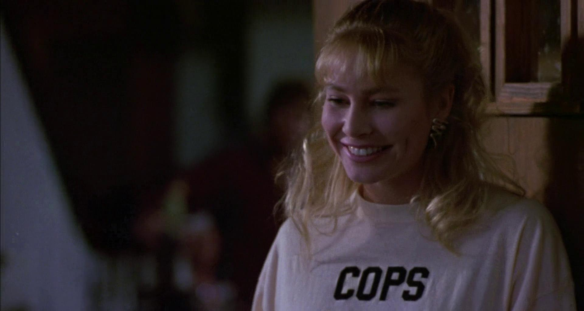 Eine Frau mit blonden Haaren, die ein T-Shirt mit der Aufschrift "COPS" trägt.