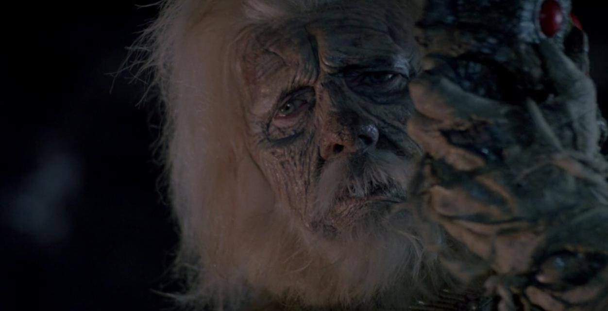 Ein gruselig aussehender alter Mann mit langen Haaren und ein Monster mit roten Augen.