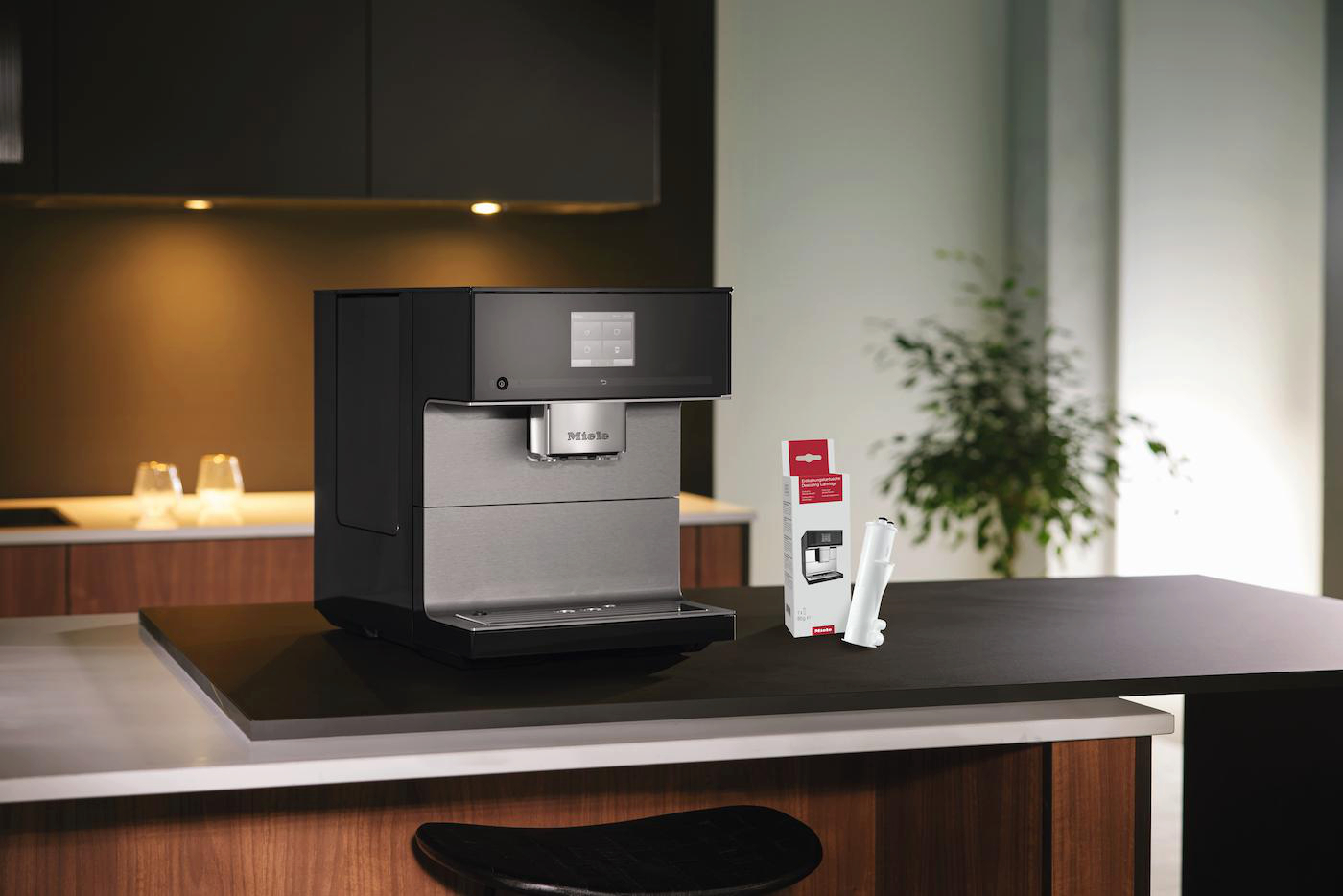 Kaffeemaschine mit Verpackung und Filter auf einem Küchentresen.