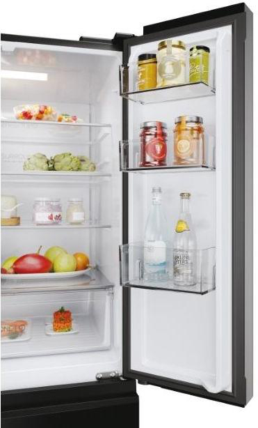 Ein offener Kühlschrank mit Lebensmitteln wie Obst, Gemüse, Gläsern und Flaschen.