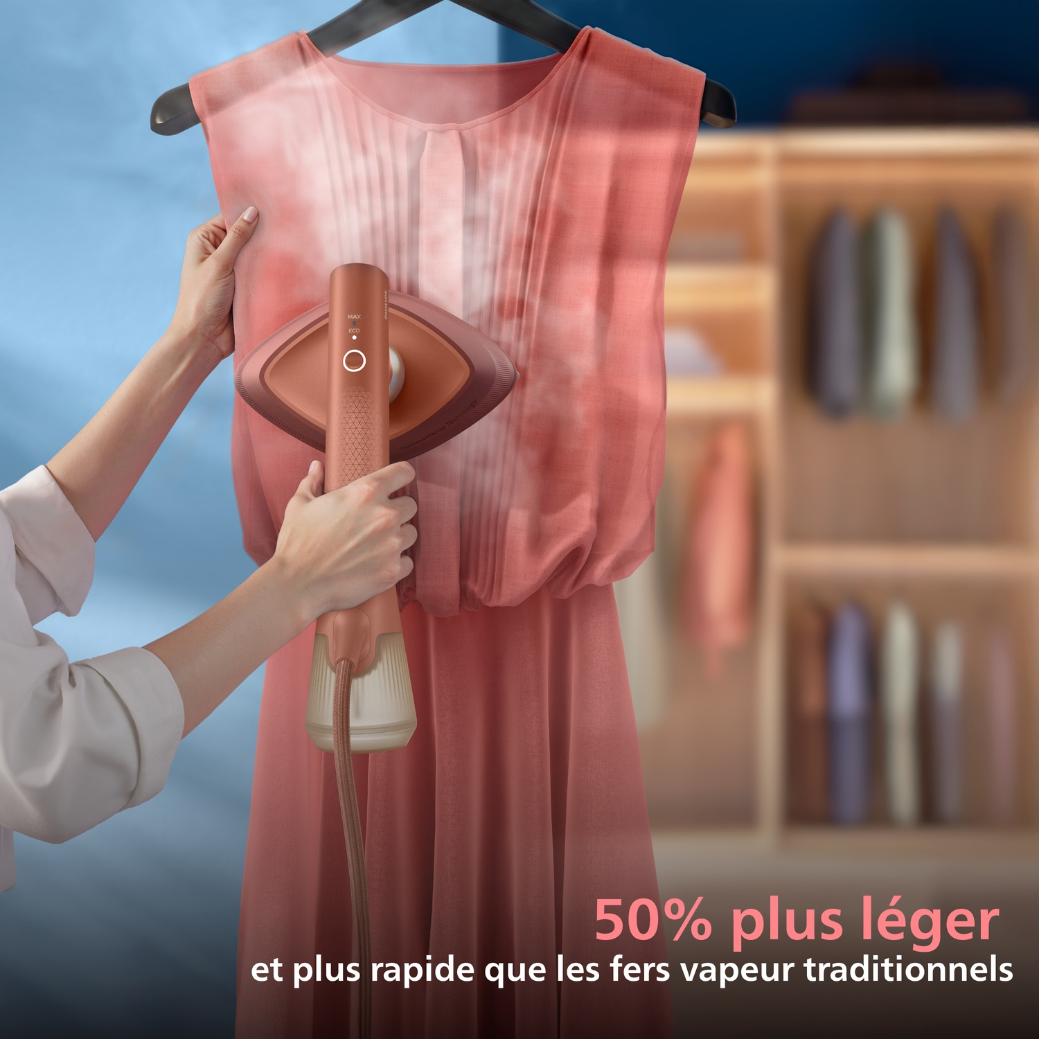 Une main utilise un défroisseur sur une robe rose.