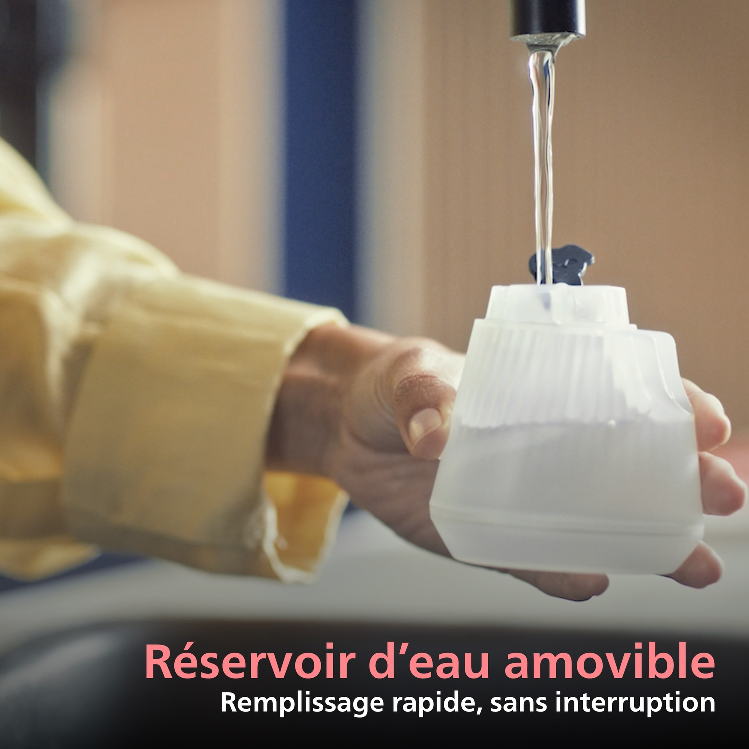 De l'eau est versée dans un réservoir amovible.