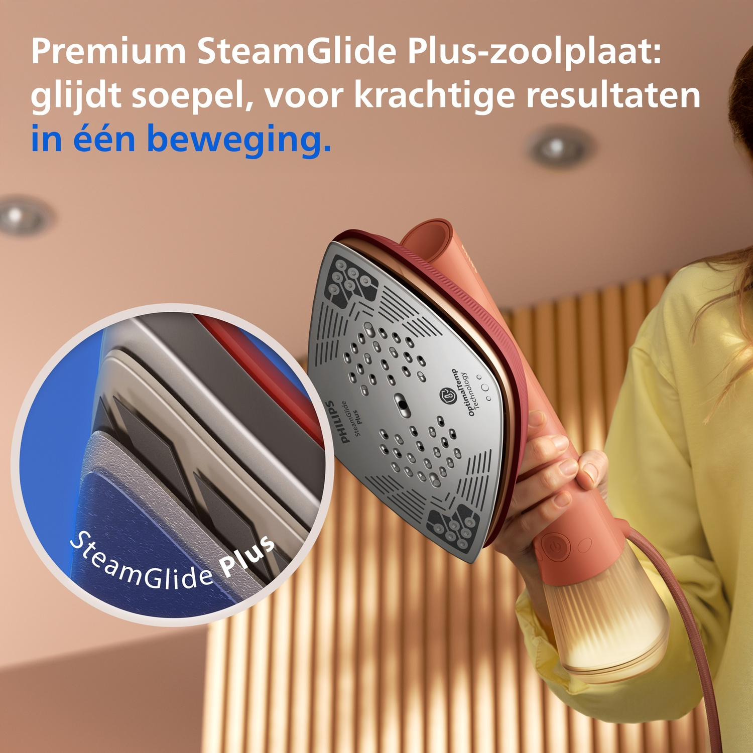 A person holds a pink steam iron with a silver soleplate, showing SteamGlide Plus.