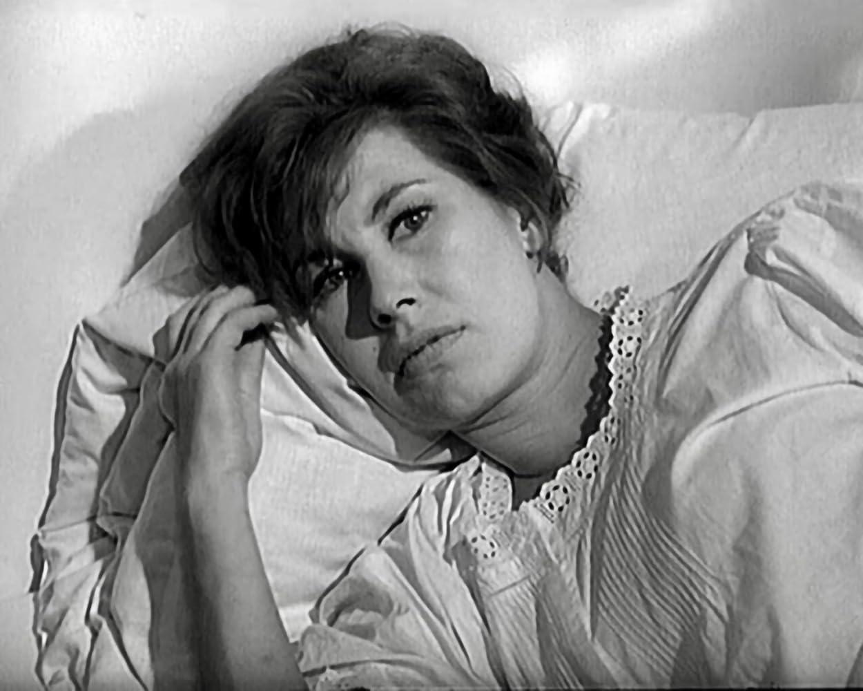 Eine Frau liegt im Bett, ihr Gesicht ist nach oben gerichtet.
