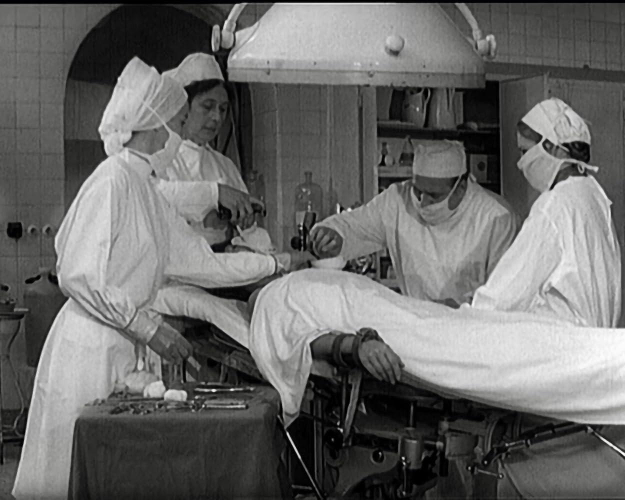 Ärzte in OP-Kleidung führen eine Operation an einem Patienten auf einem Tisch durch.