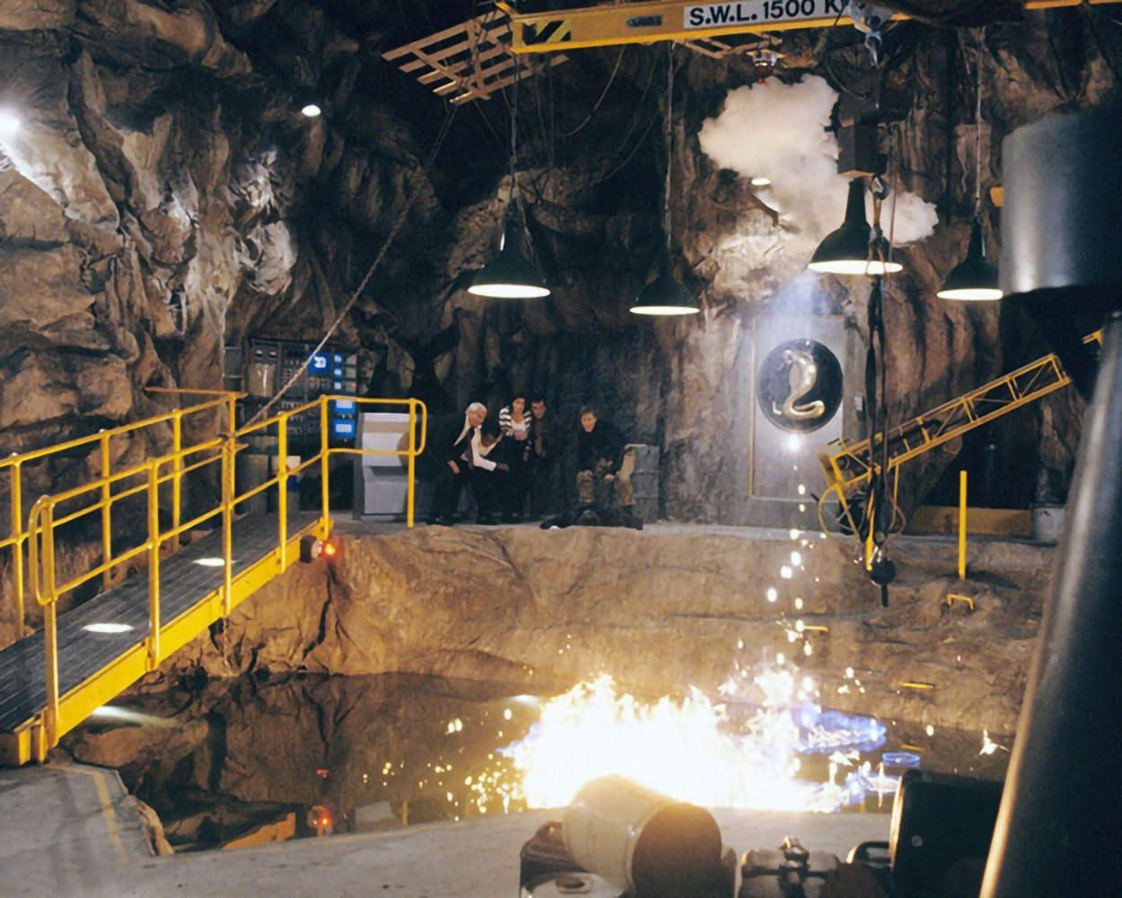 Eine Höhle mit gelben Geländern, Flammen und einer Schlangenfigur an der Wand.