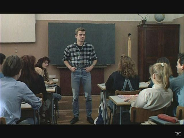Ein junger Mann steht vor einer Klasse von Schülern im Klassenzimmer.