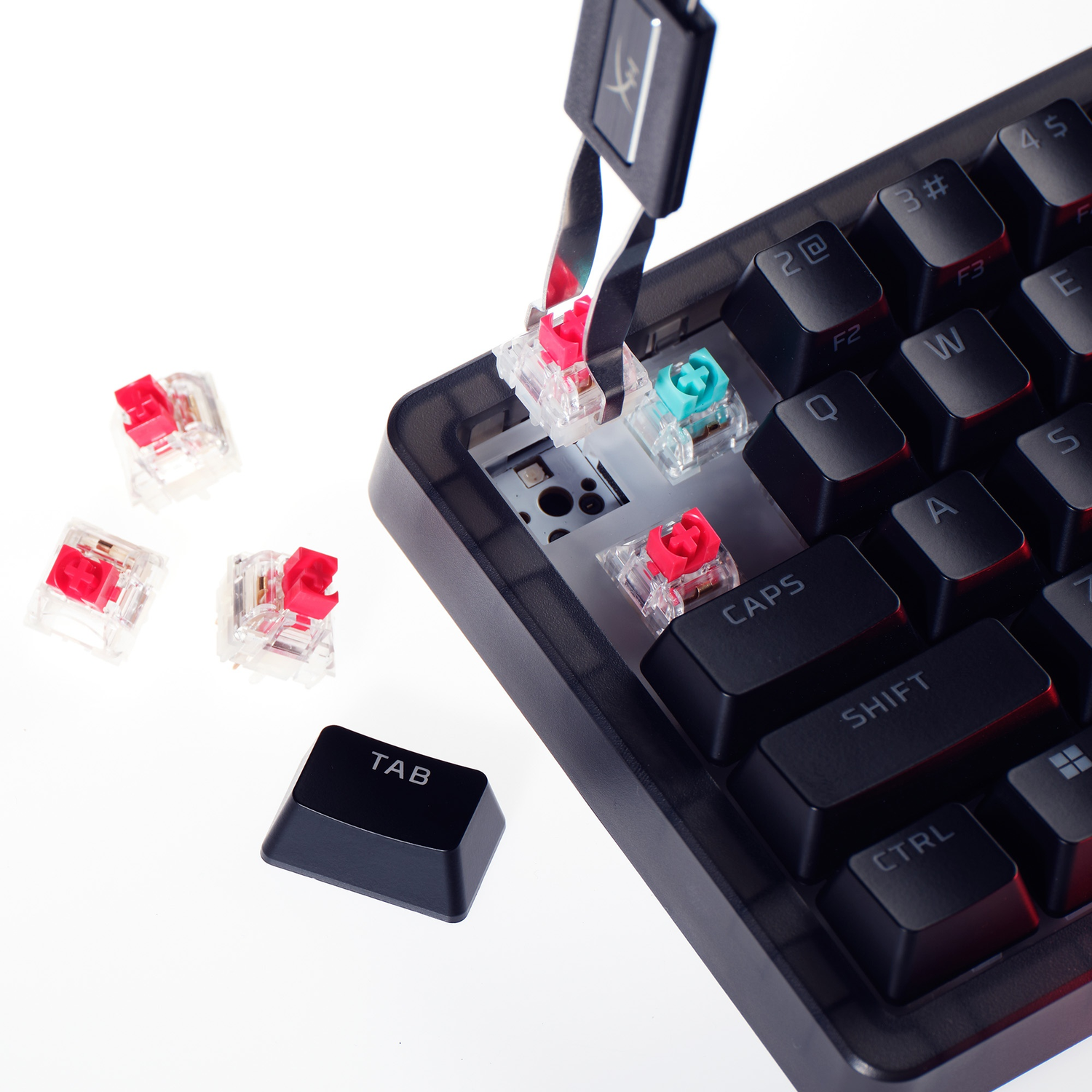 Mechanical keyboard switches in red and green, with a keycap and tool.