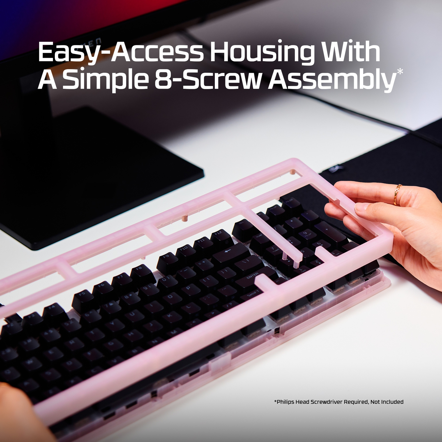 A person assembling a pink housing onto a black keyboard.
