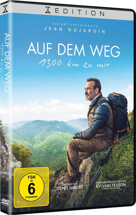 Ein Mann mit Rucksack sitzt auf einem Felsen in den Bergen.