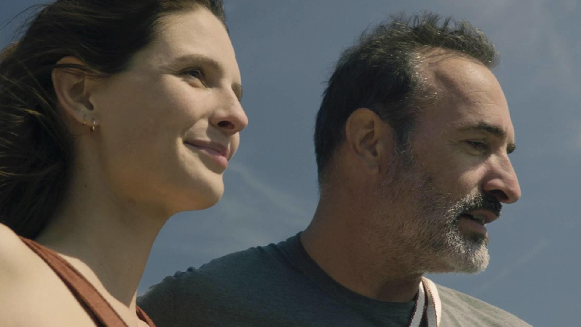 Frau und Mann im Profil vor blauem Himmel, sie lächelt.