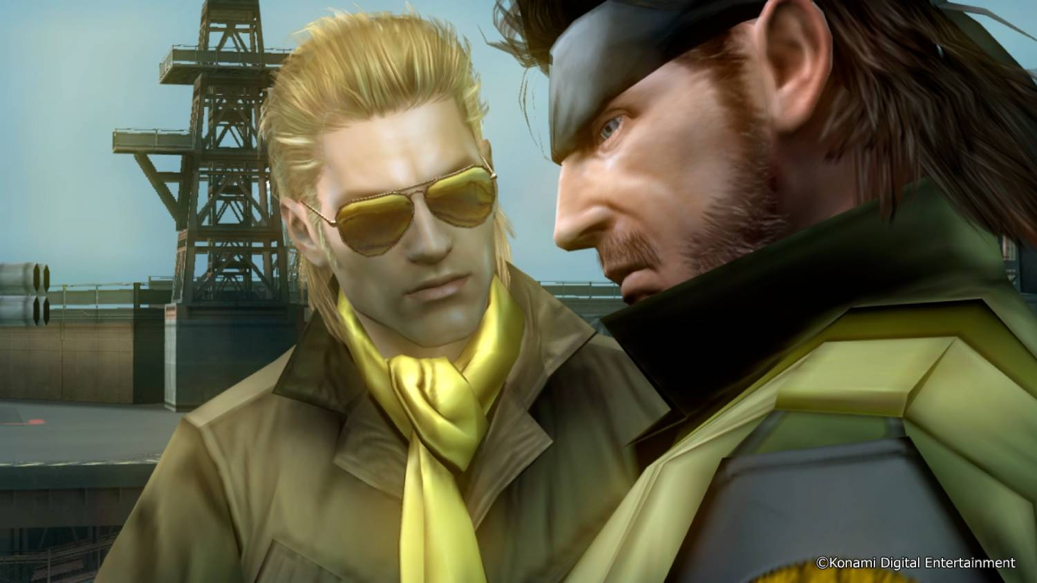 Dos hombres conversando frente a una estructura industrial.
