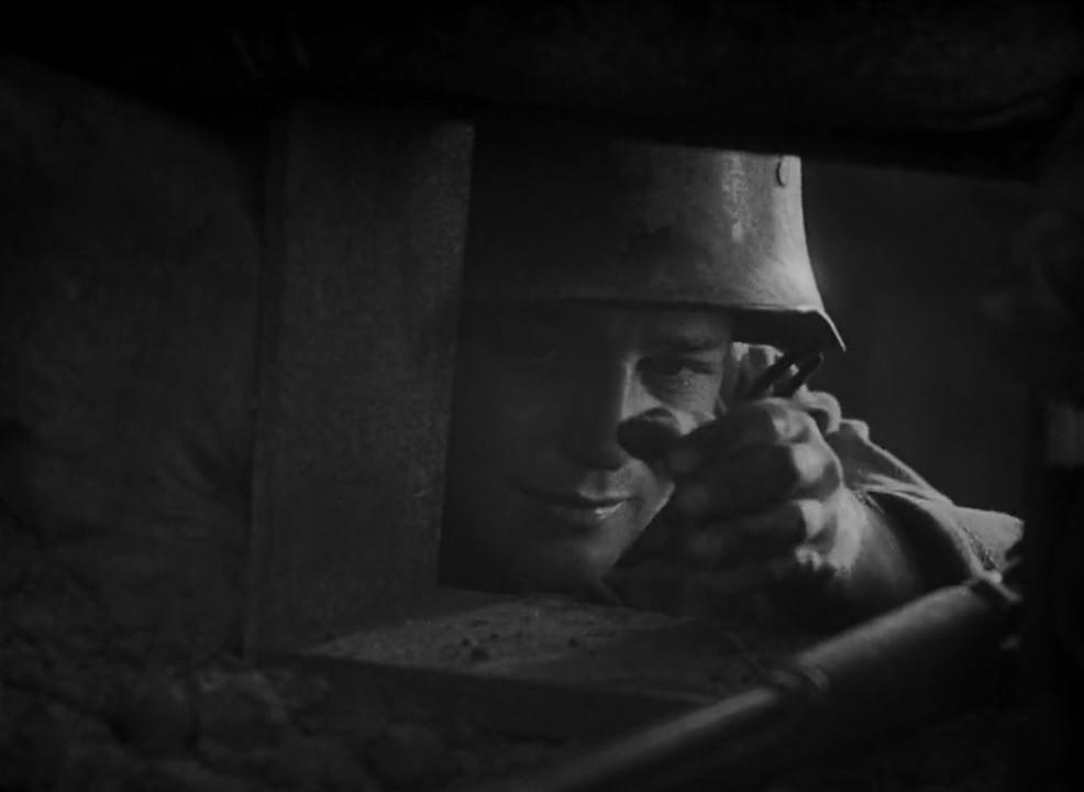 Ein Soldat in einem Helm blickt aus einem Schützengraben.