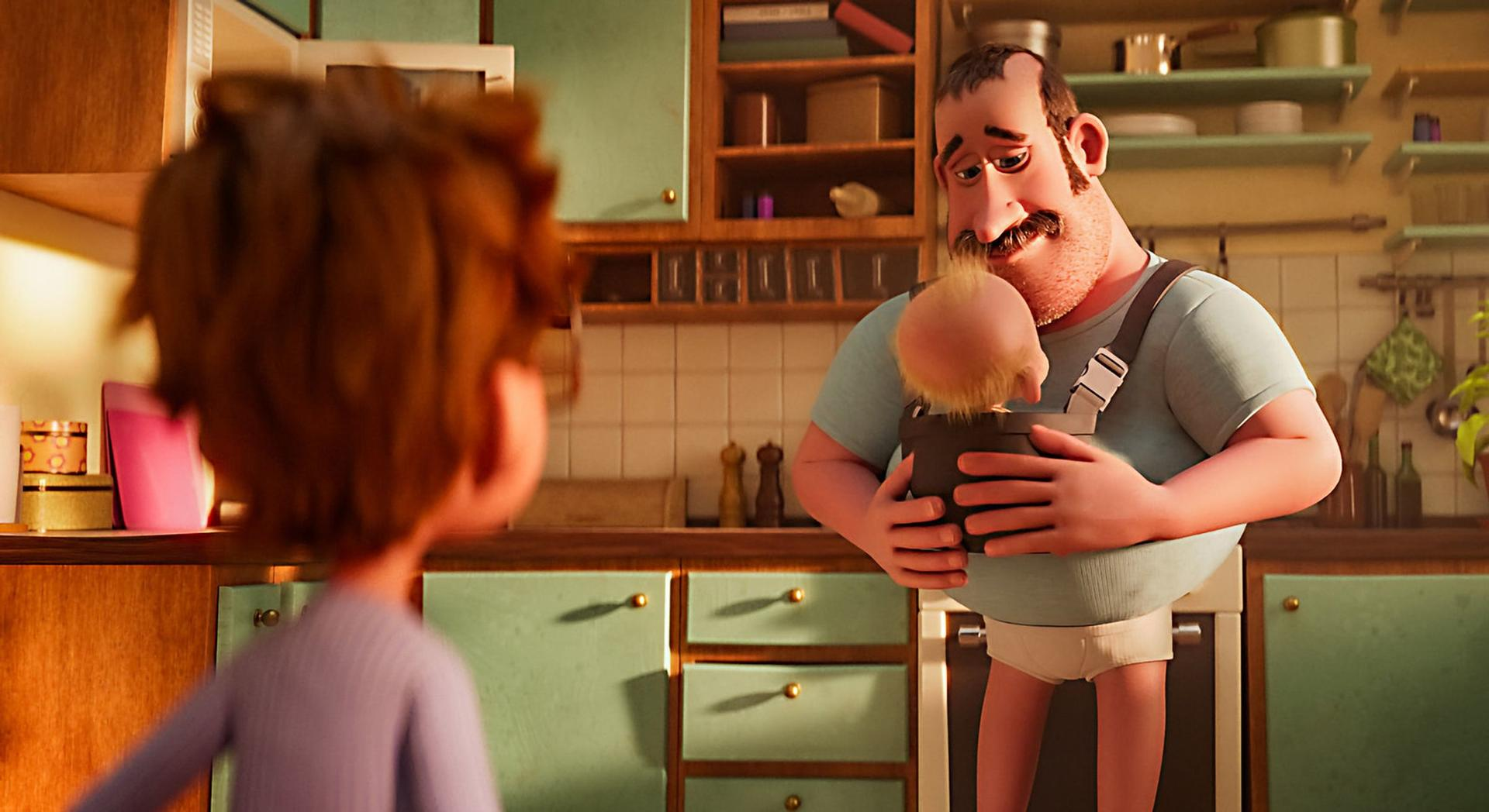 Ein Mann mit Schnurrbart hält ein Baby in einer Trage in einer Küche.