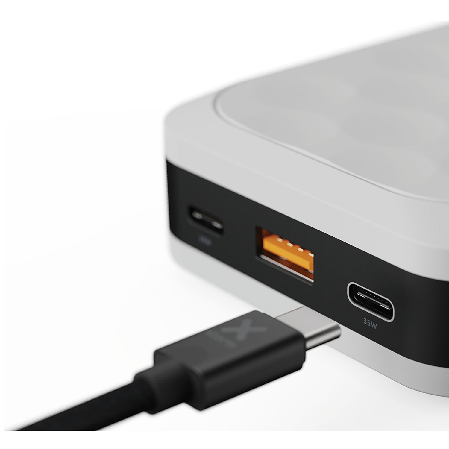 A black USB-C cable is plugged into a white and black power bank device.